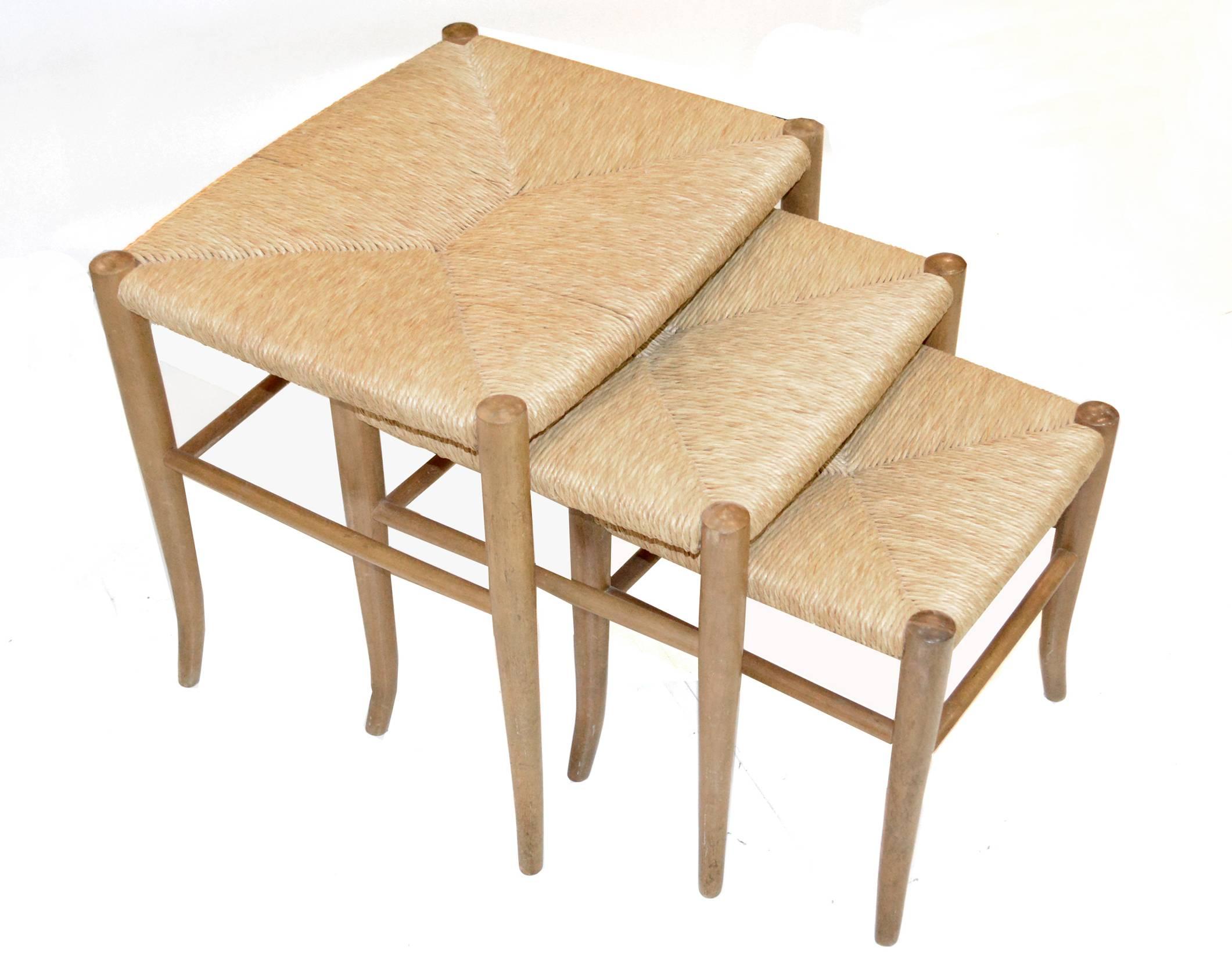 Lovely set of nesting stools with tapered ash legs and woven rush seats in the manner of Gio Ponti. 
Measures: Large: 20" wide, 16.5" deep, 18" high.
Medium: 17" wide, 15.5" deep, 16" high
Small: 13.5" wide,