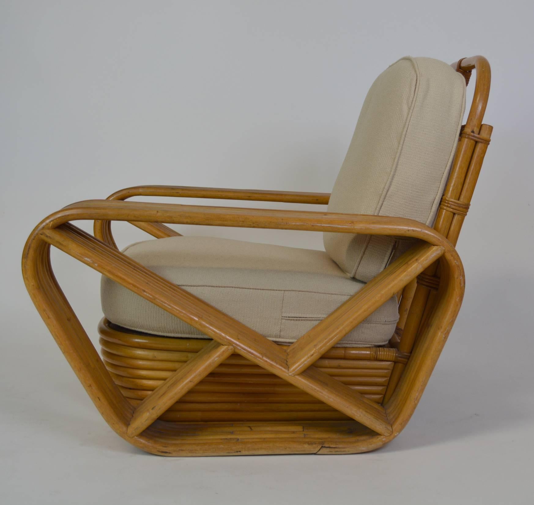 A pair of Art Deco Paul Frankl style rattan lounge chairs by Tochiku Industries, Japan. With new cushions and upholstery. six strand rattan arms. Ottoman available separately.