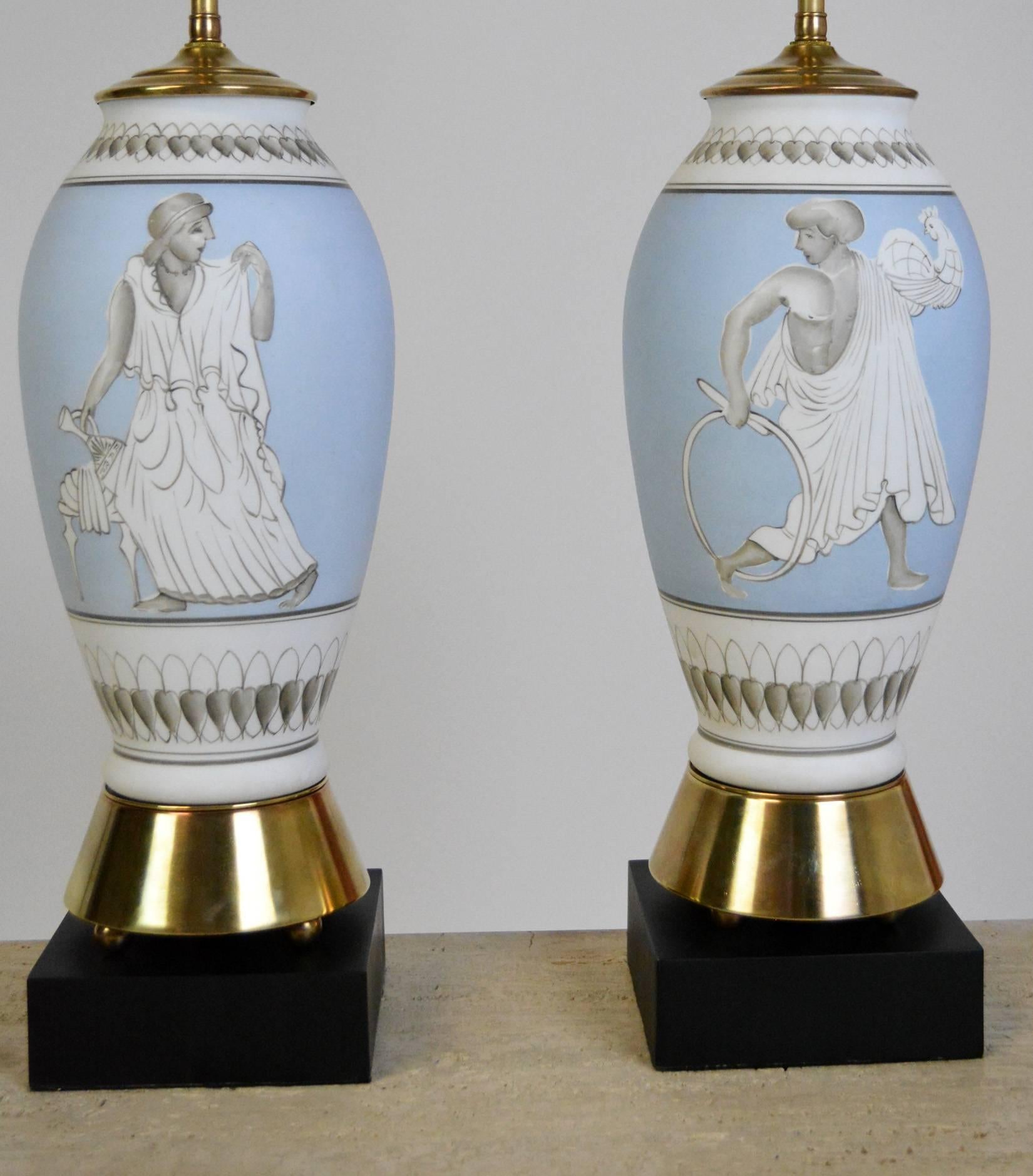A pair of lamps with matte glazed ceramic in cornflower blue and white with grey decoration. Each lamp is unique, with a hand drawn classical figure in Roman togas. Rewired with new double cluster sockets and original mounts polished.