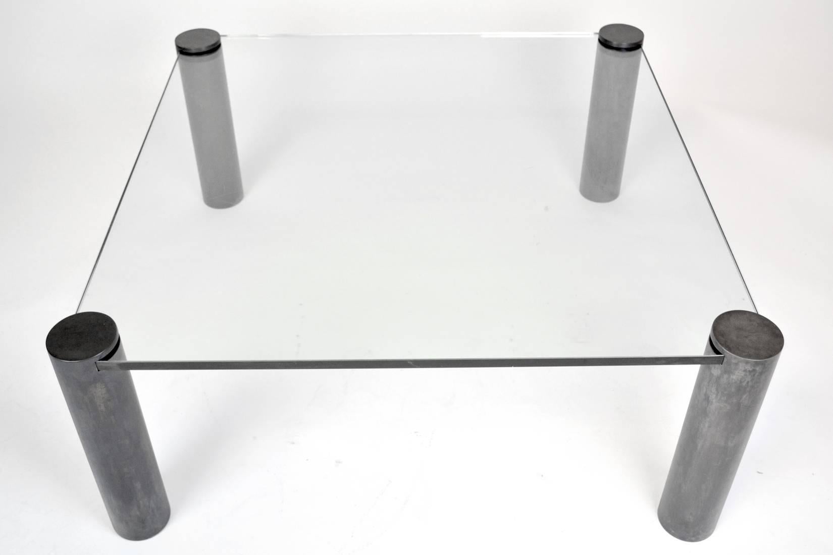 A chic coffee table with four cylinder legs that grasp the thick square glass top. The legs are brass with a dark gunmetal patina. In the style of Karl Springer and Pace.
Measure: Overall 40 ½” width x 40 ½” length x 17 ¼” height (top of glass) and