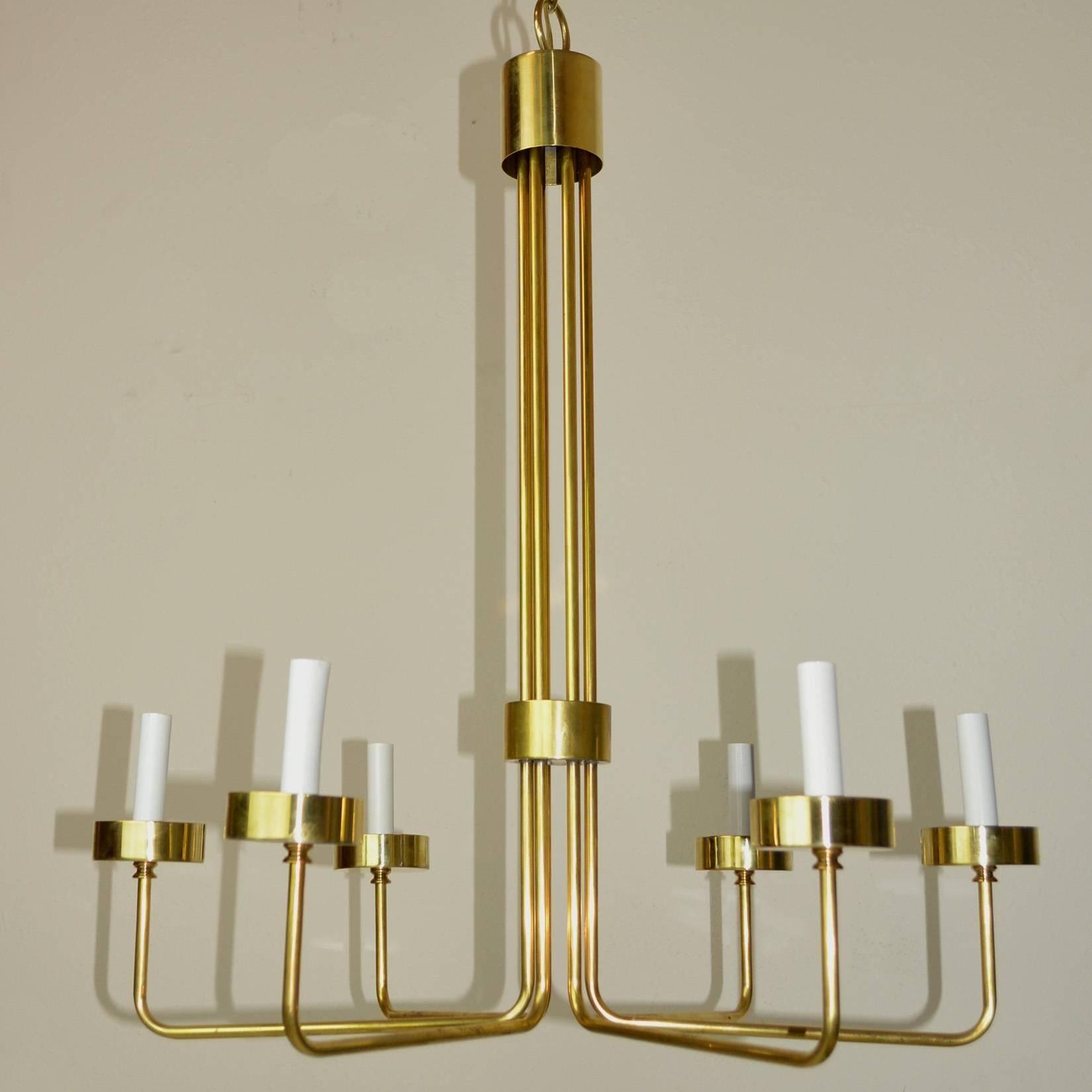 A Minimalist angular six-light chandelier. Six brass rods form a central group and spread out to each light. Brass bobeche cap each rod. In the style of Solaris.