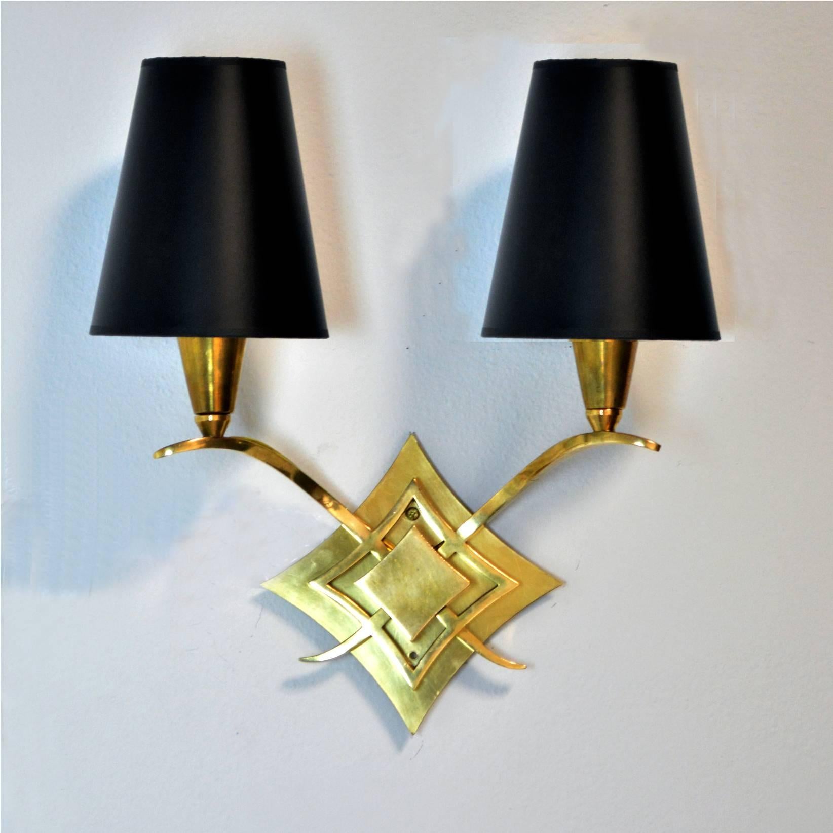 A set of four Mid-Century Modern French sconces, attributed to Jules Leleu but not marked. Each sconce has been rewired and takes a US candelabra base bulb. New, solid brass, shaped backplate for US installation, can be removed or painted if