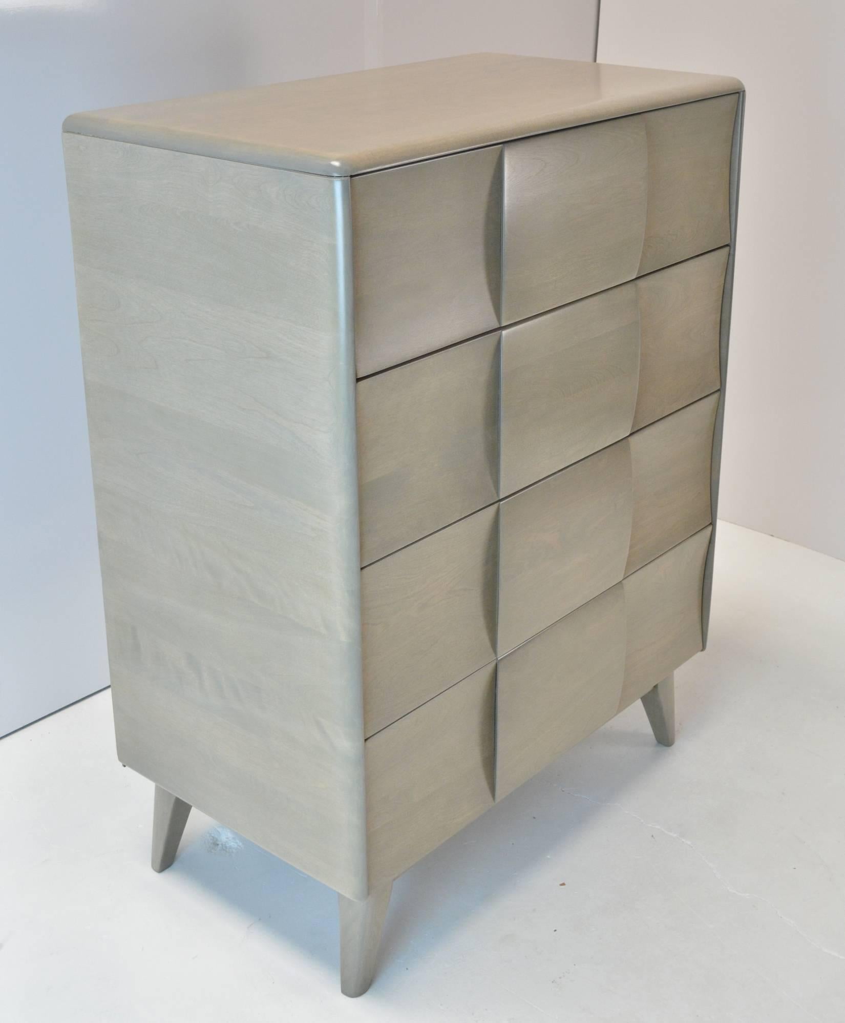 A Mid-Century Modern four-drawer chest with sculptural block front and shaped legs. Refinished in a silver grey stain.