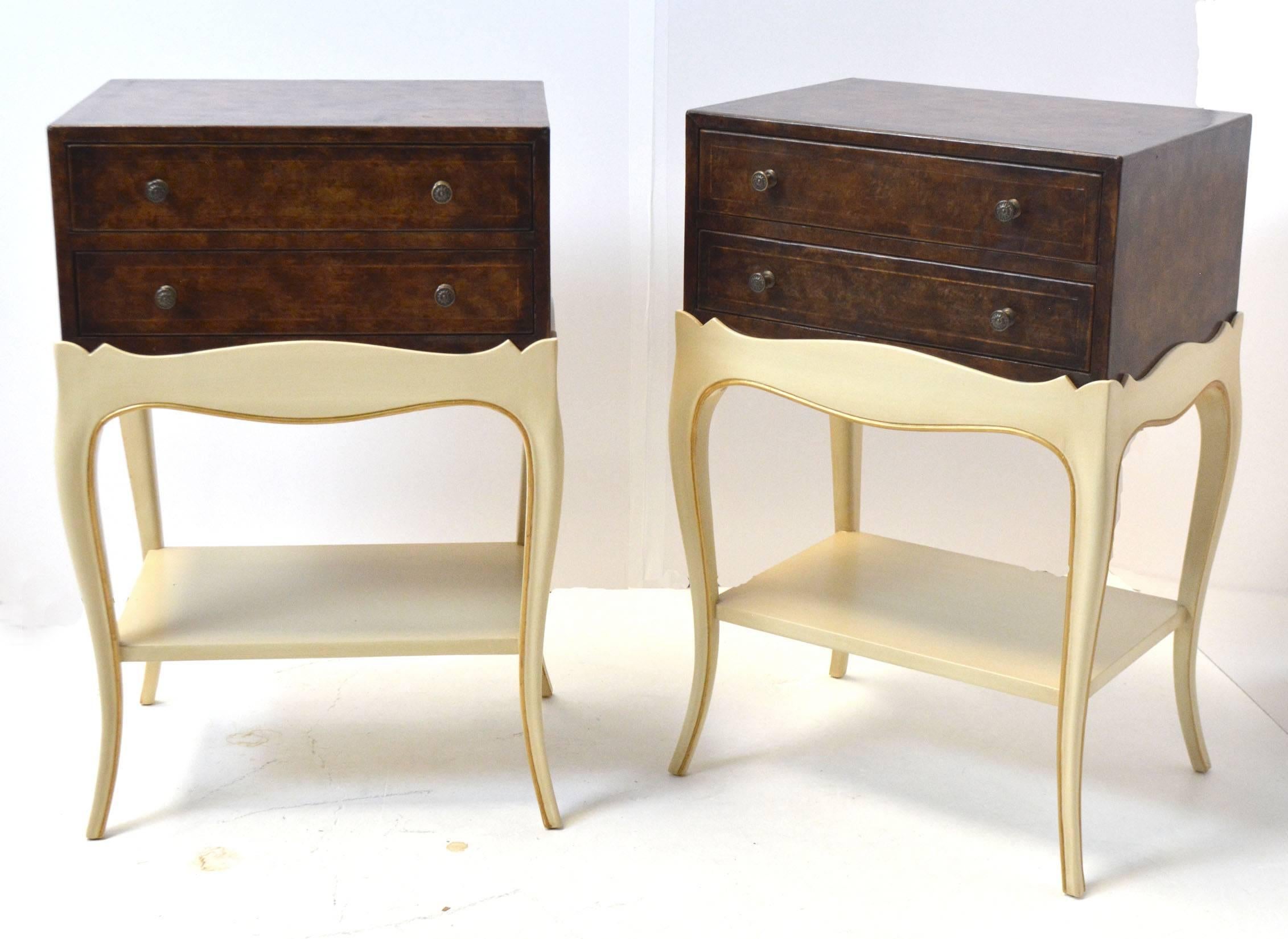 A pair of nightstands or occasional tables by Grosfeld House, circa 1940's. A two drawer leather wrapped chest sits on a painted base with cabriole legs and a shelf. Top measures 18" x 13", base measures 19" x 14", 28.25"