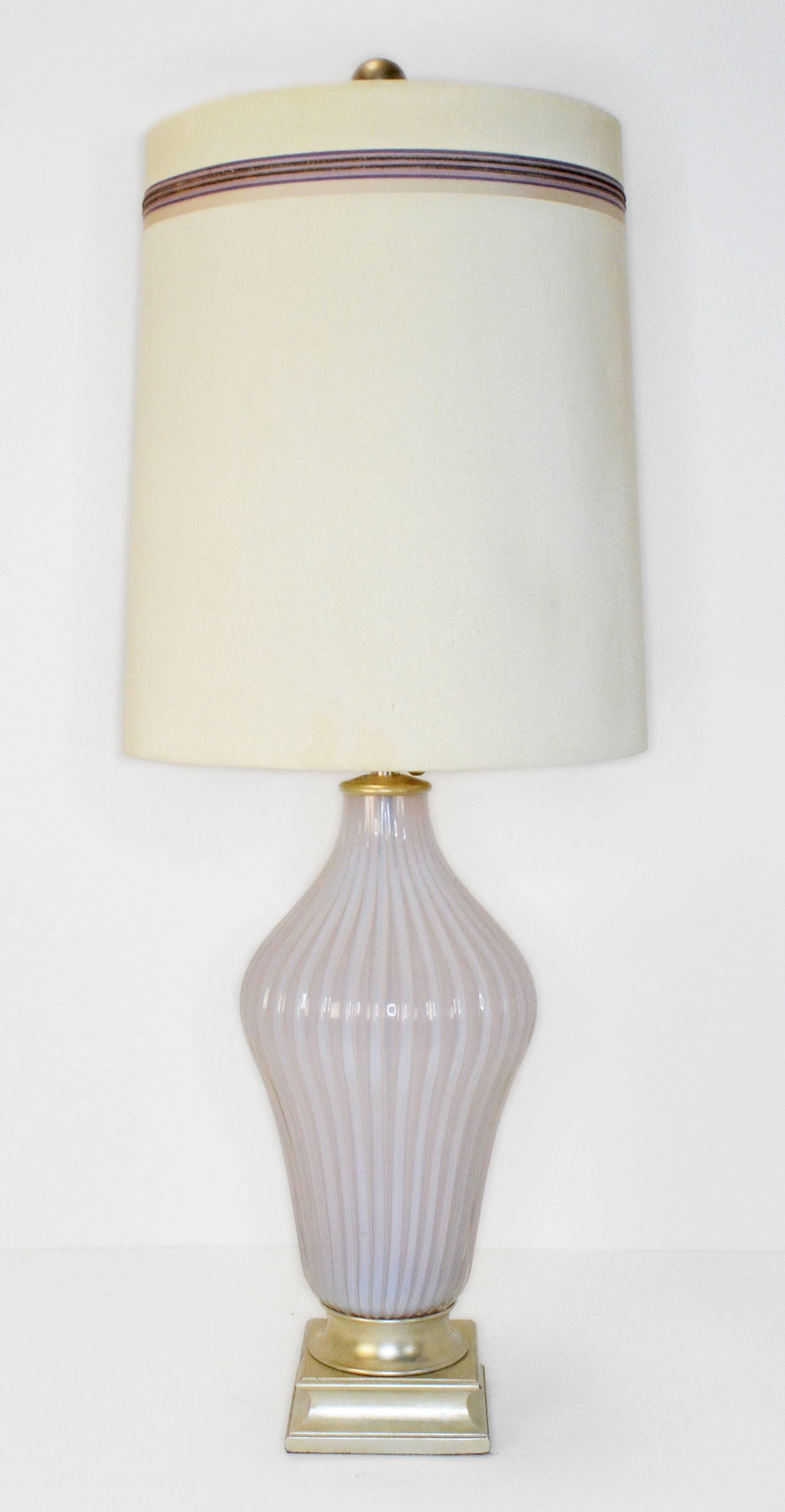 A rare pair of vintage Murano table lamps by Seguso for Marbro. Ribbed Murano opaline glass lamps in a light blush pink retailed by The Marbro Lamp Company on original silver leafed bases. The soft glow of the opaline glass is amazing. Lamps have