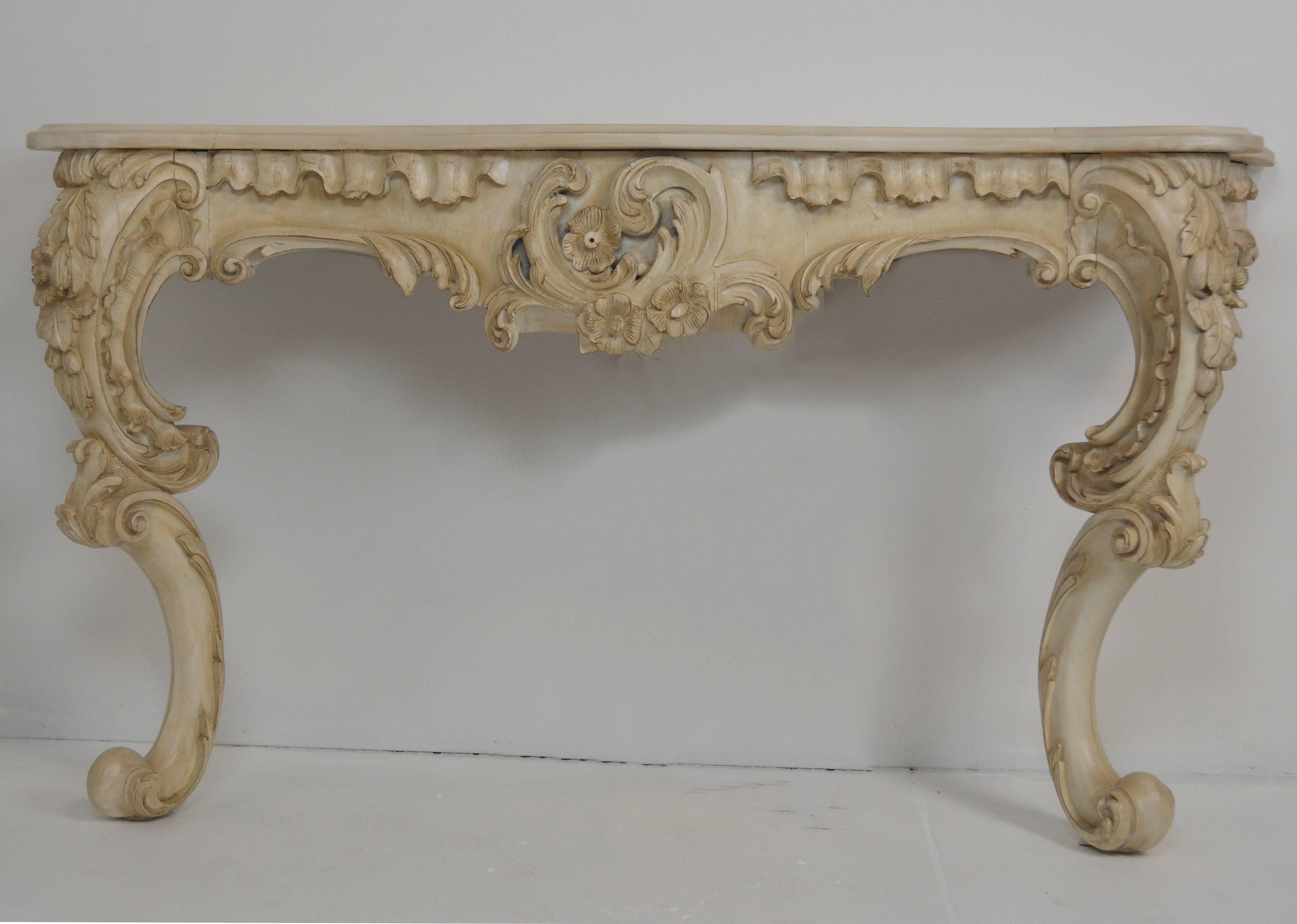 A good quality Rococo style console, with carved cabriole legs and apron and a shaped top.