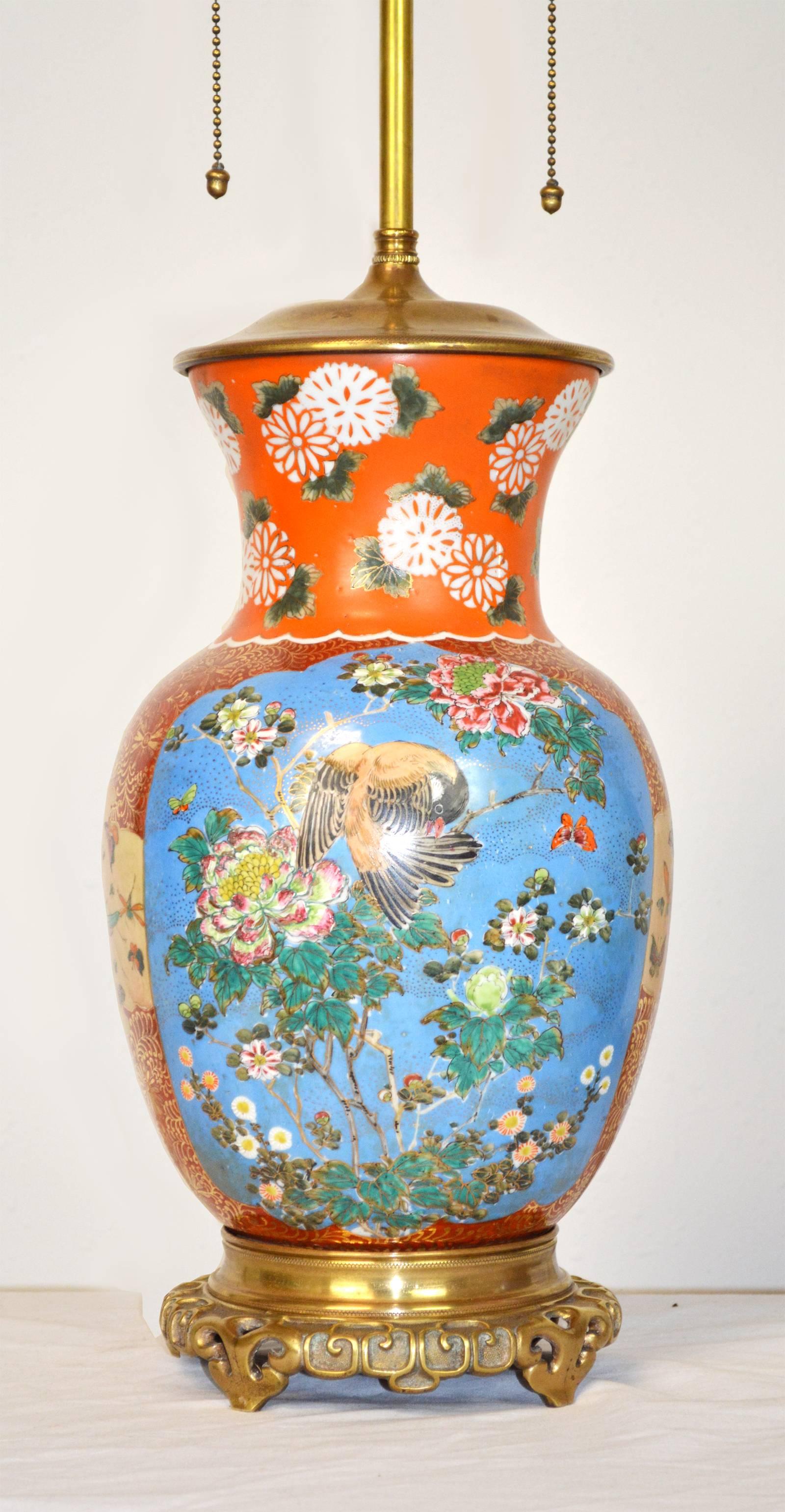 A stunning pair of 19th century Japanese Imari porcelain vases with period gilt bronze mounts. Unique coloration with blue and orange panels containing floral and bird motifs. Professionally rewired with new sockets. Height to top of porcelain is