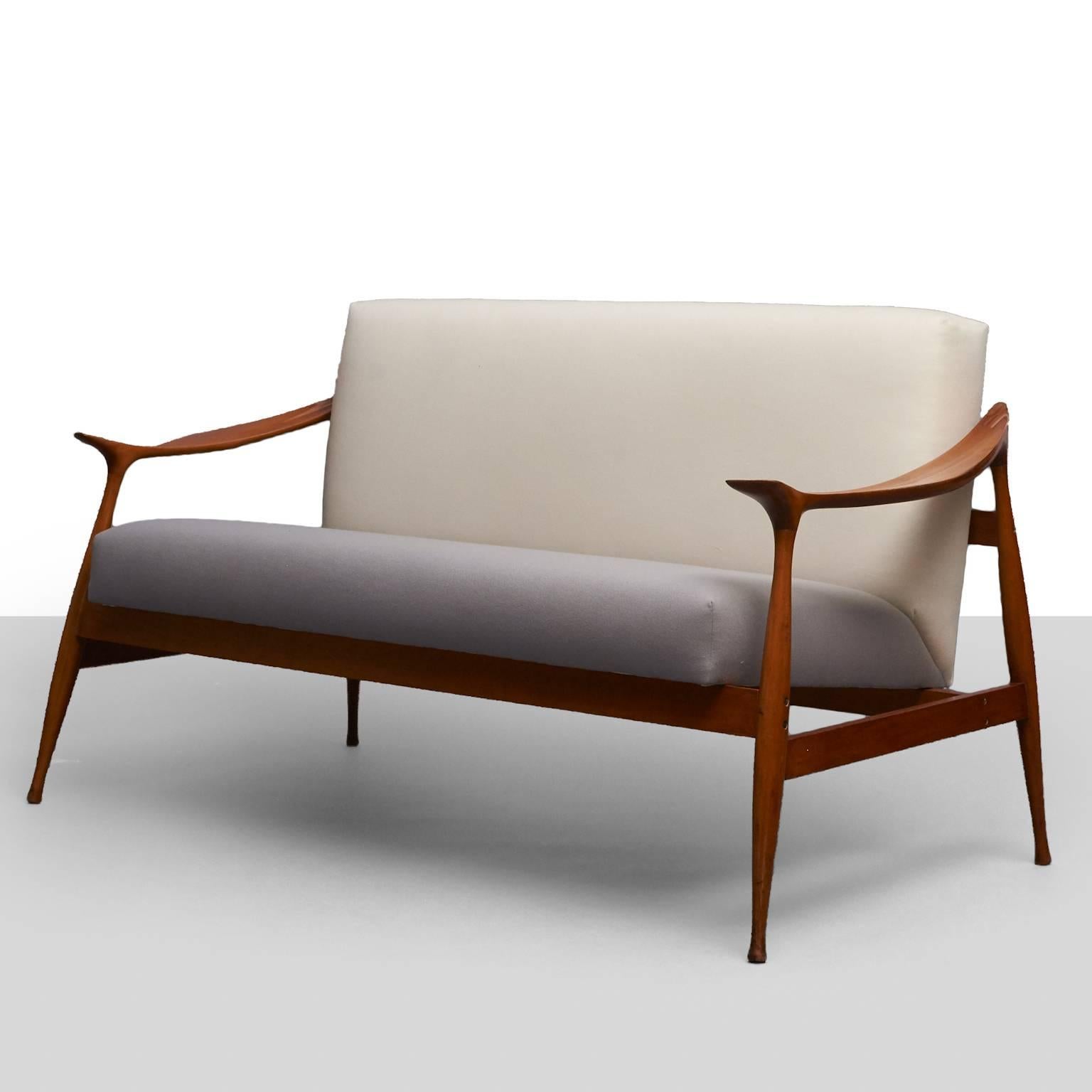 A “Lord” settee of walnut and upholstery by Ico Parisi for Fratelli Reguitti.
 