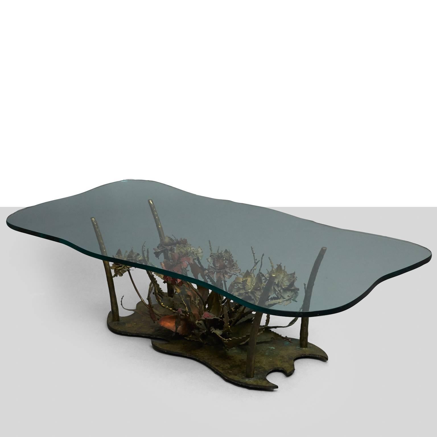 A Brutalist coffee table by Silas Seandel as part of his Woodland series. Featuring an amorphous glass top upon a steel sculptural floral base.