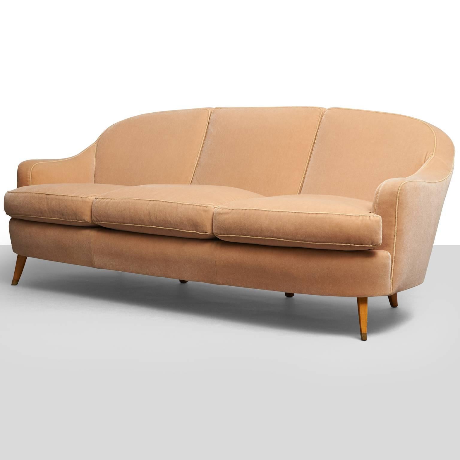 A sofa by Jules Leleu. Legs fitted with gilt brass, recently restored in velvet with contrast cord trim.