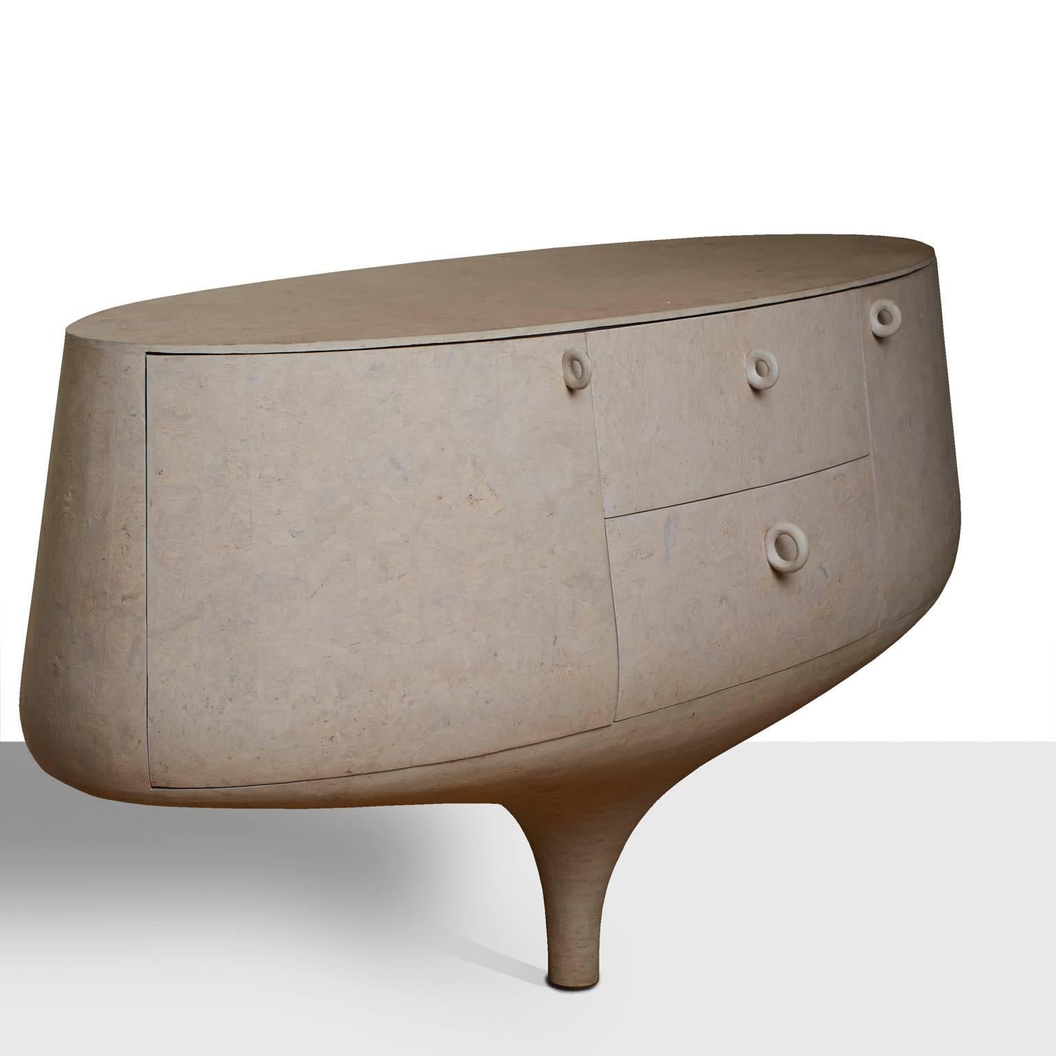 A “Mirage” dresser in a beautiful elliptical shape by Dutch furniture maker Patrick Schols. Supported by a single fluted leg and secured to wall. Features two cabinets and two drawers with unique handle pulls. Interior painted in lavender.
   