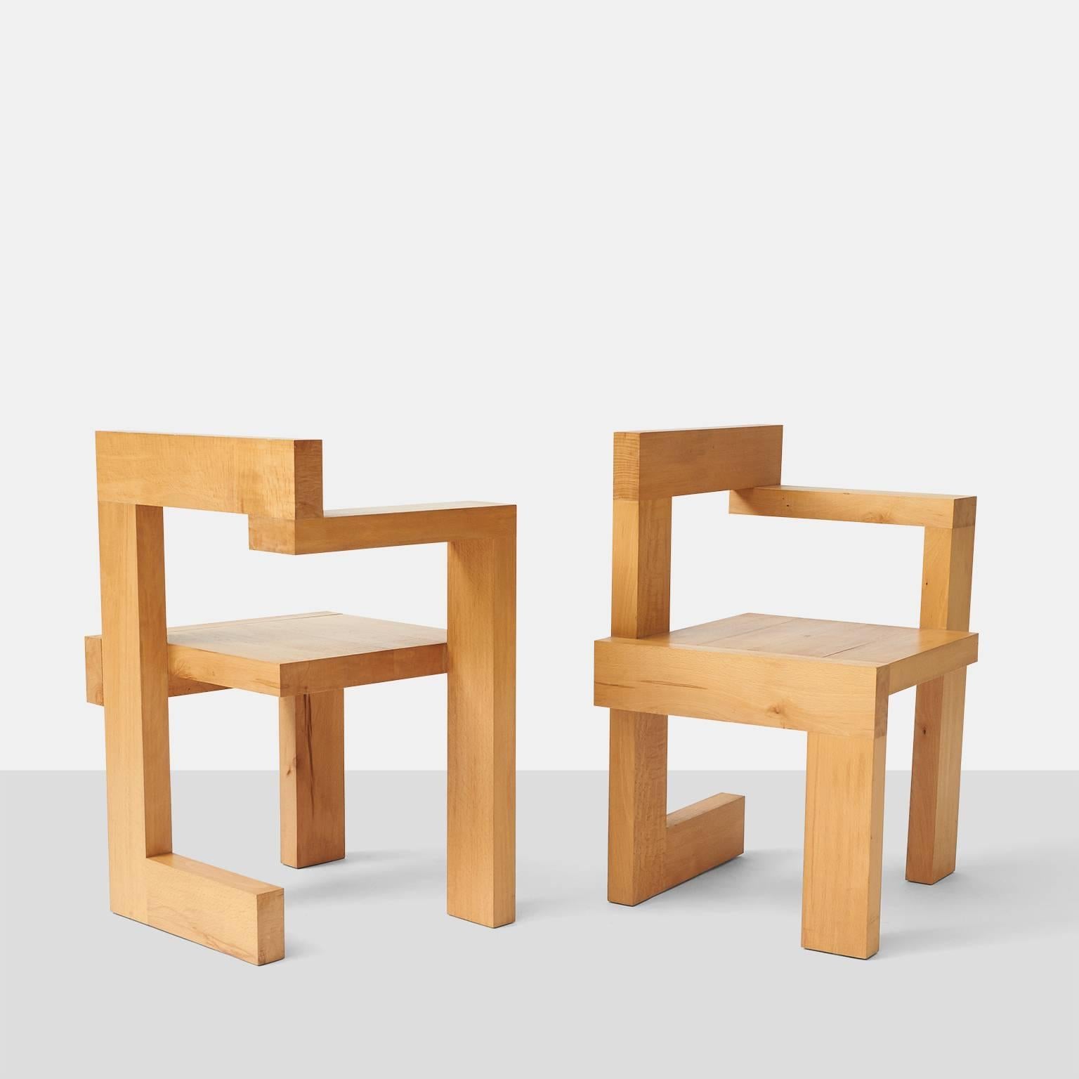 A pair of chairs in oak by Gerrit Rietveld, one with a left arm and the other with a right arm.  The chairs were designed  in 1963 for the Steltman Jewelry store in the Hague. 