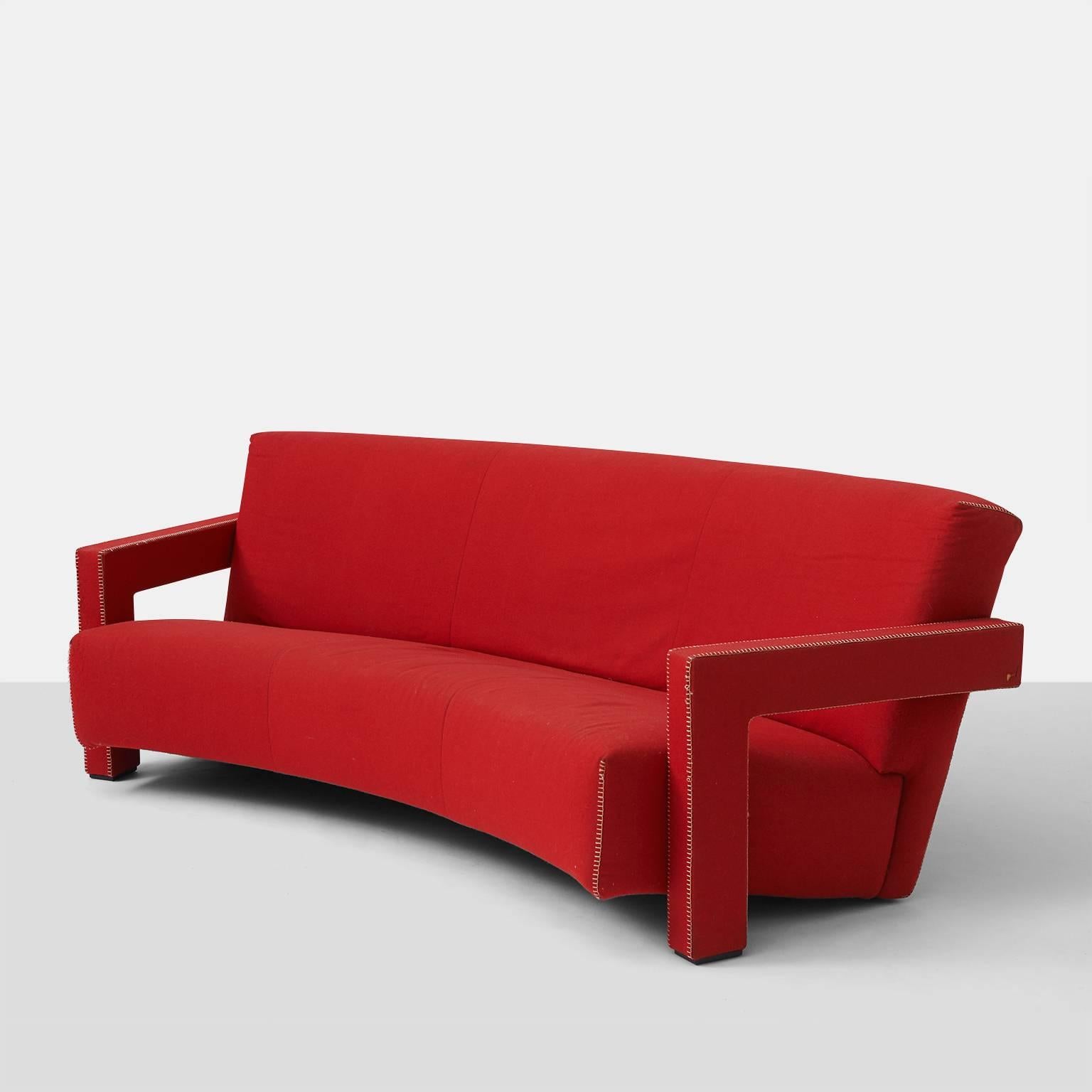 A very early edition of Gerrit Rietveld's Utrecht sofa designed in 1935 and made by Cassina in the late 1960s. This curved back sofa retains the original red wool flannel fabric with ivory hemstitch trim. Original label and signature are intact.