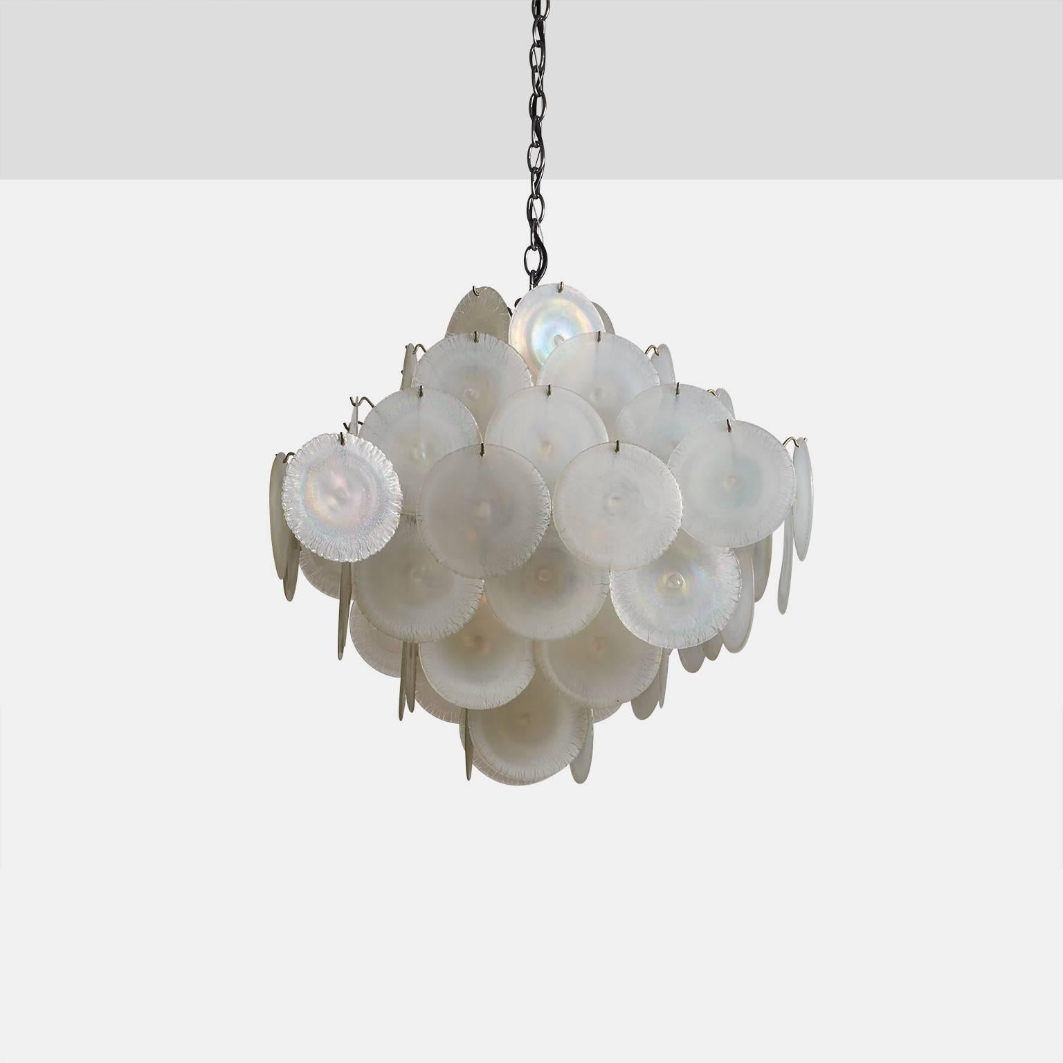 A large Vistosi chandelier made in Italy in the 1960s. The chandelier contains 68 Murano iridescent glass discs that conceal 12 European size candelabra base sockets.