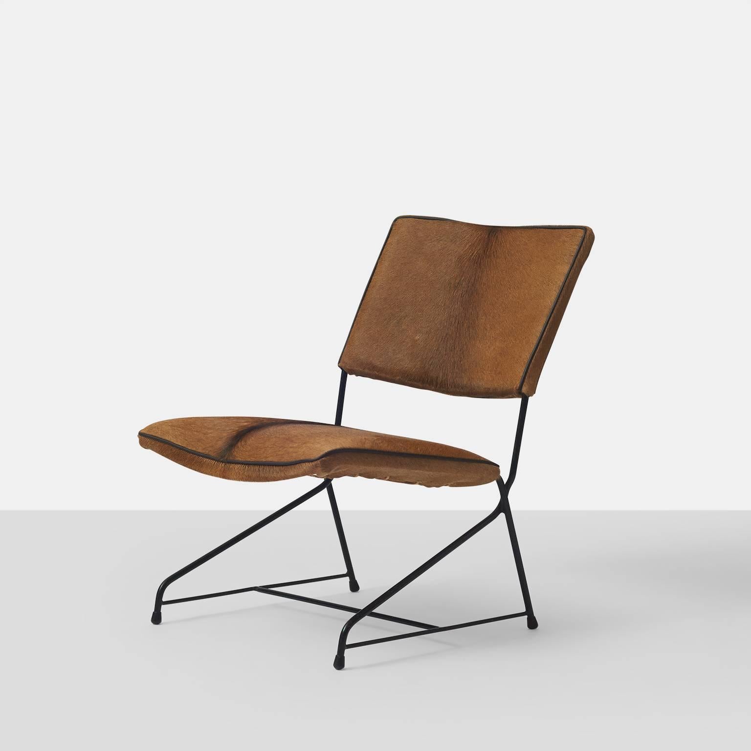 A lounge chair with an iron frame and cantilevered seat restored in a hair on hide with leather trim. Made in Italy in the 1950s. The frame is reminiscent of versions made by Arflex and Augusto Bozzi.