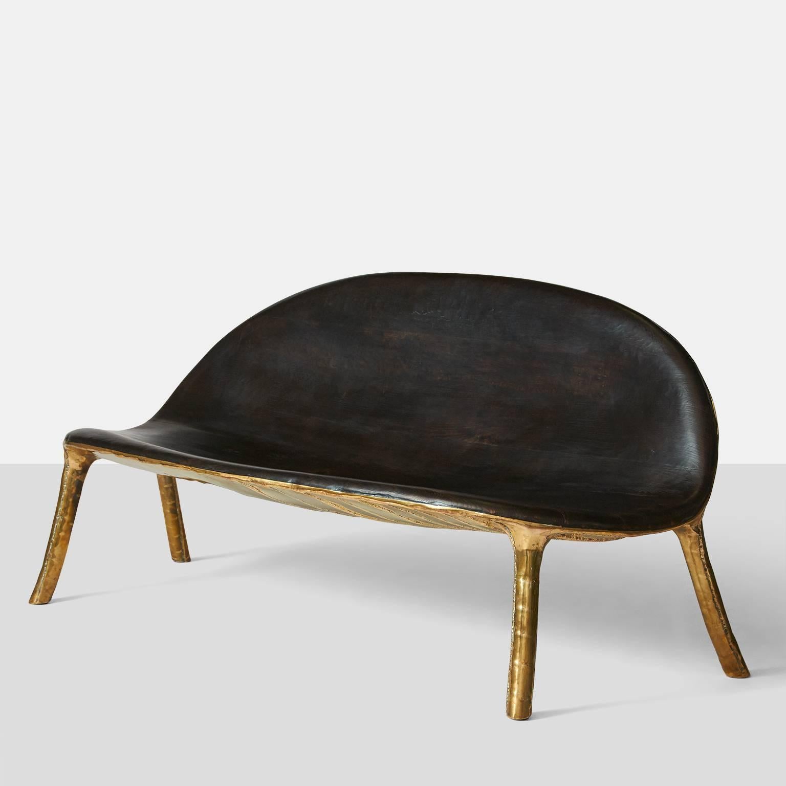 A sofa by German furniture designer Valentine Loellmann made in 2015. Completely hand constructed in brass and not cast, with a charred oak seat and back that has been made to fit the curved shape. The brass construction creates a unique pattern on