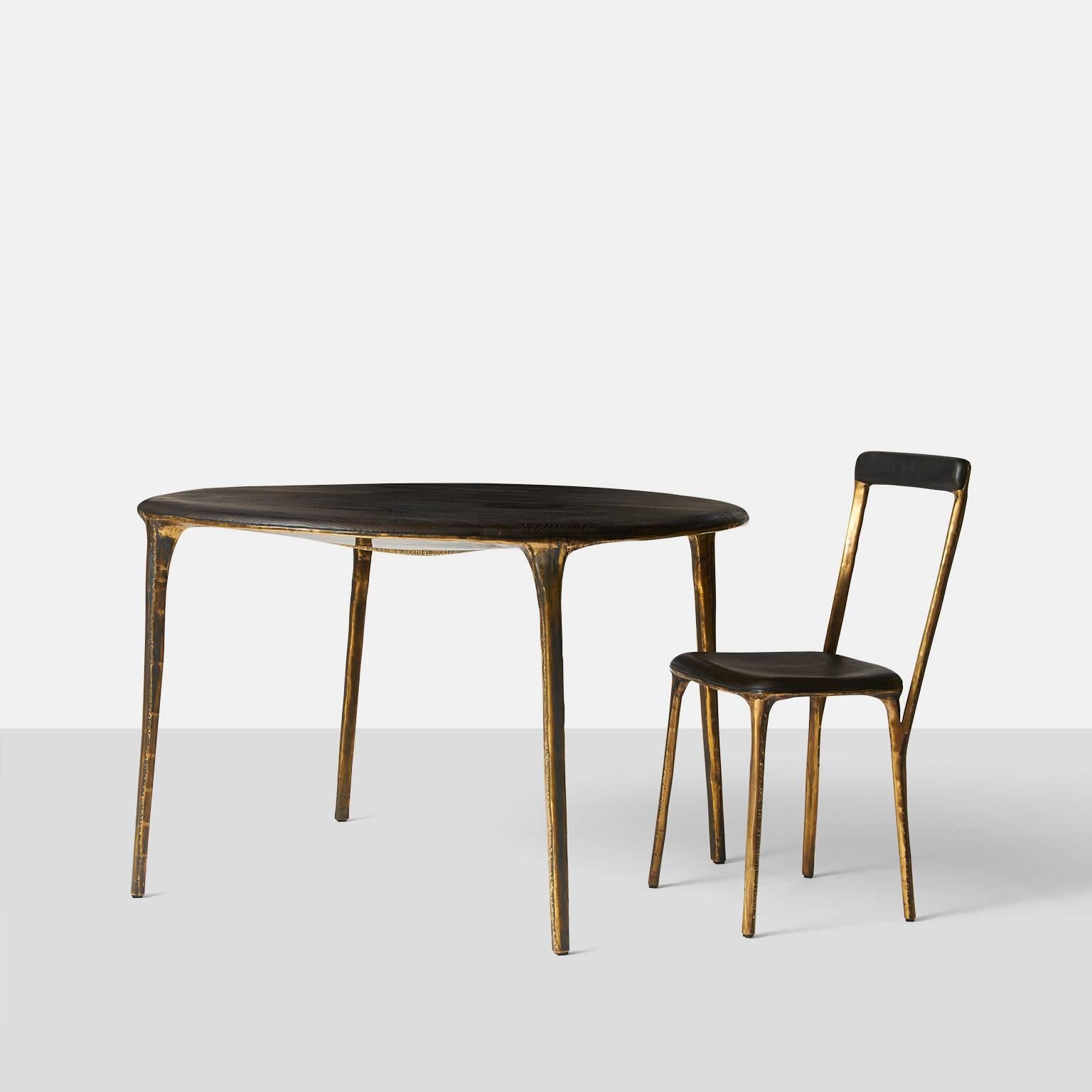 A dining table by German furniture maker Valentine Loellmann, circa 2015. Completely hand constructed in brass and not cast, with a charred oak tabletop. The brass construction creates a unique pattern on each piece. Almond & Company is the