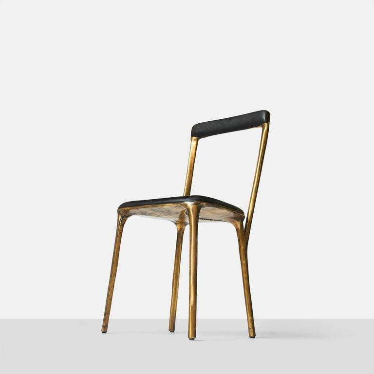 A side chair by German furniture designer Valentine Loellmann, circa 2015. Completely hand constructed in brass and not cast, with a charred oak seat and back that has been made to fit the curved shape. The brass construction creates a unique