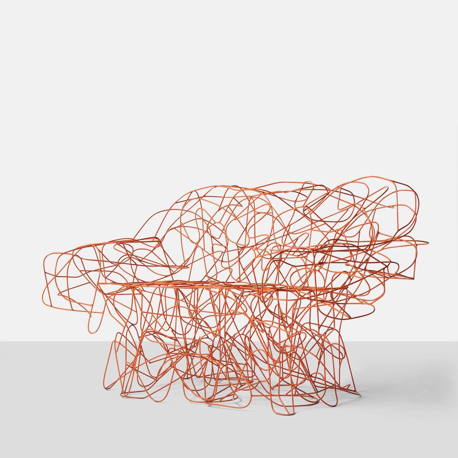 A sofa that is formed by the Campana Brothers from an irregular weave of stainless steel wire and painted with a coral color epoxy paint. Each piece of wire has been bent and soldered by hand and then smoothed to eliminate any sharp edges. The sofa