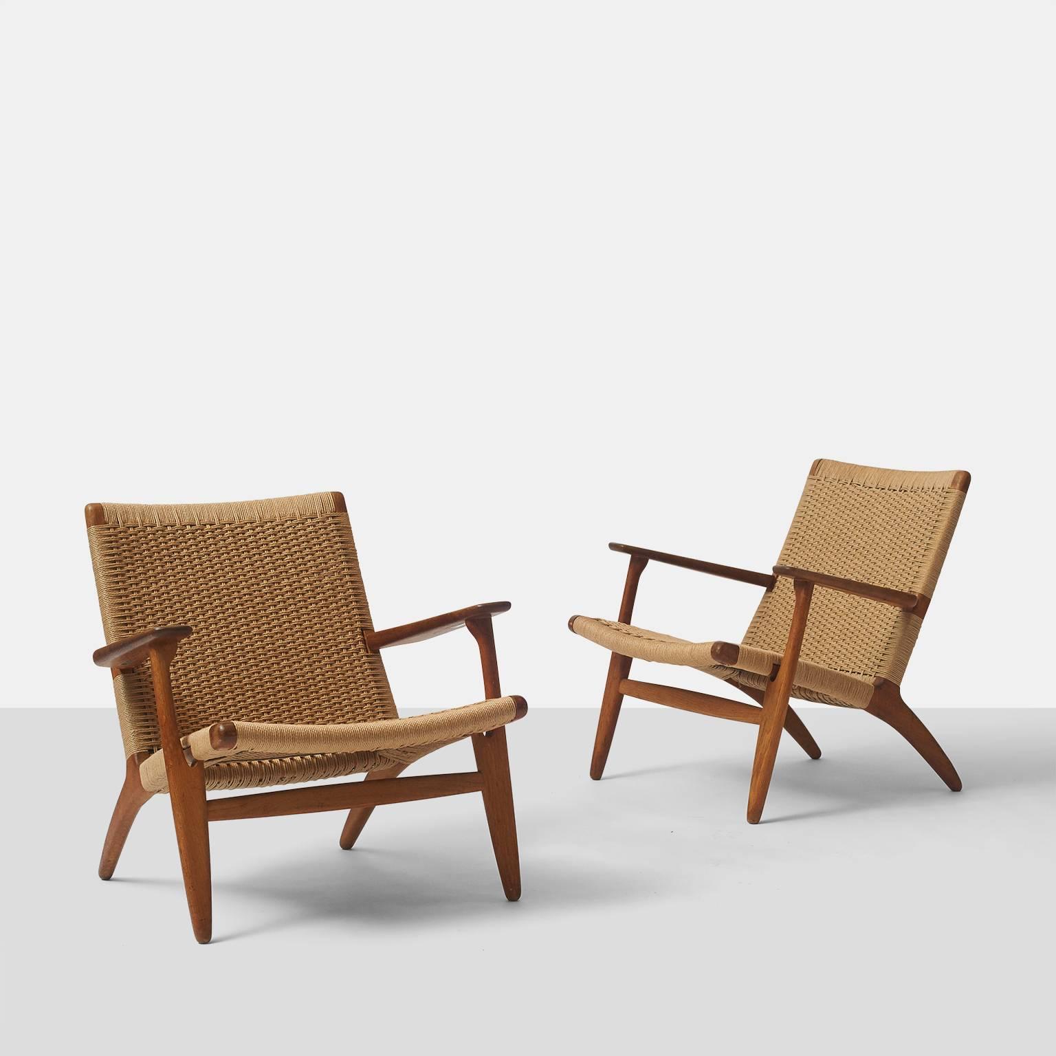 A pair of lounge chairs model #CH 25 by Hans Wegner in oak with the original woven paper cord seat and back. Each is in excellent condition with beautiful oak patina, circa 1950s, Denmark.