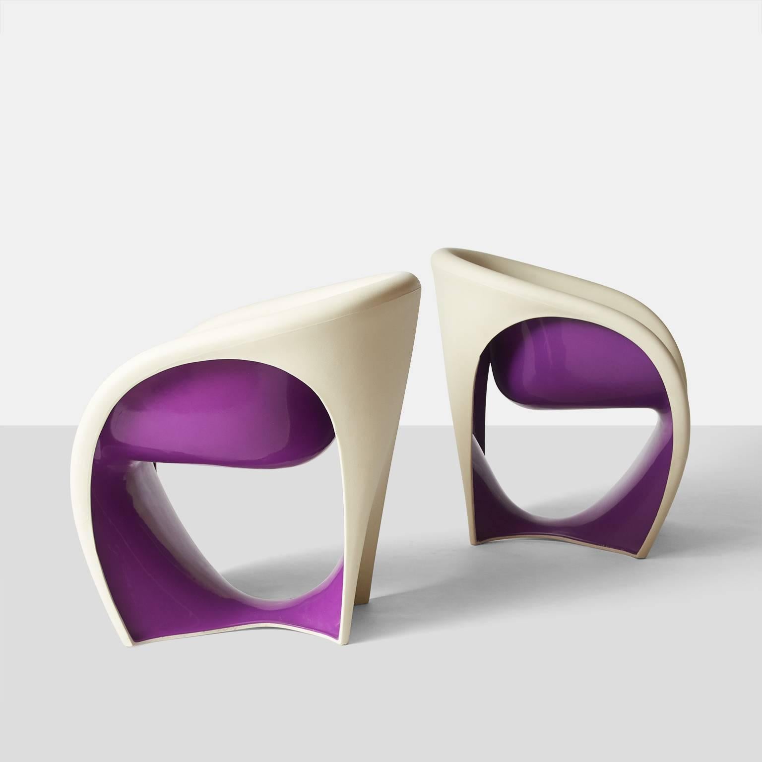 A pair of MT-1 lounge chairs by Ron Arad for Driade. Each is made of rotational molded polyethylene with white exterior color and deep purple underside. Manufacturer's stamp on base.
