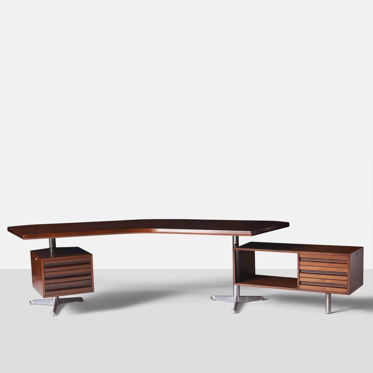 An executive desk made in rosewood and polished aluminum for ENI furnishings and retains the original label, Tecno Milano. The desk has a boomerang shaped top which floats over two tabourets that rotate 180 degrees. Both have three drawers and one