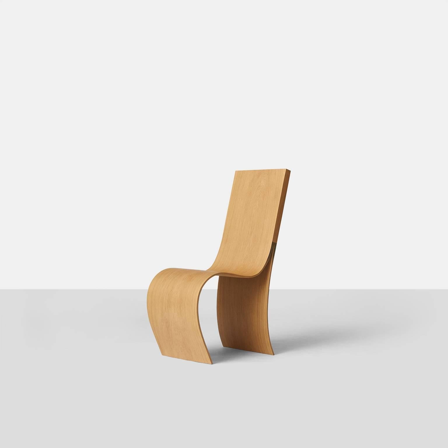 A completely handcrafted chair by Belgian artist Kaspar Hamacher. Made of a solid slab of oak from naturally fallen trees. The slab has been split in multiple layers and then shaped to create the soft curve of the seat. An Almond & Co. U.S.