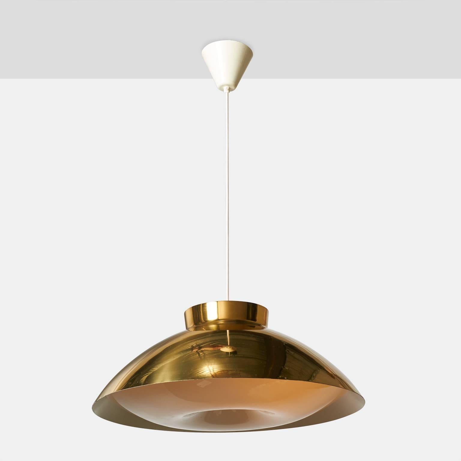 A large pendant with a brass shade that fits over a shaped plexiglass diffuser attached with a brass rosette in the center. There are three original porcelain Edison base sockets concealed inside. Made for Orno, Finland, circa 1950.