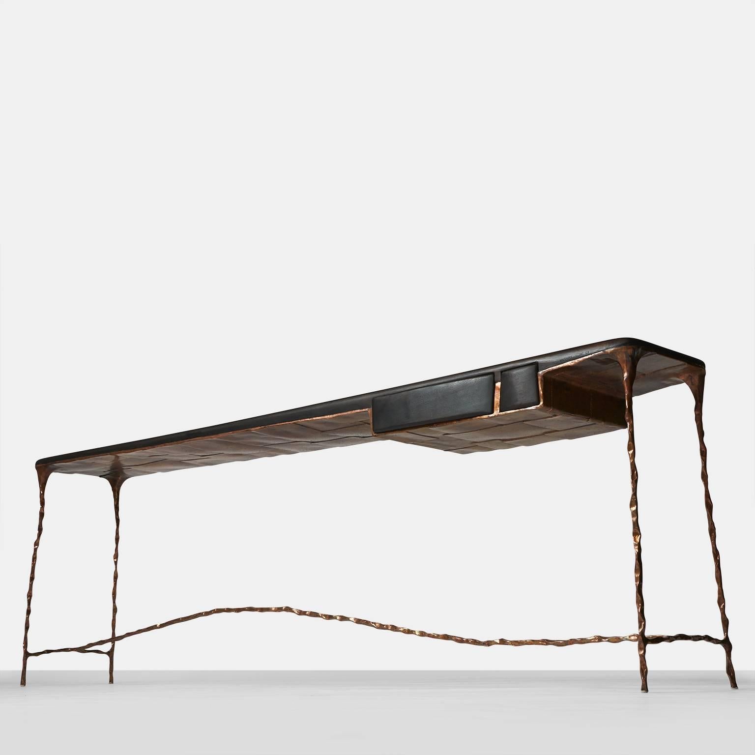 An elongated console table or desk made with a solid hand-forged copper base and a charred oak top. The desk features two drawers each in different dimensions and the back side has matching false drawers.   With all custom produced items, each will
