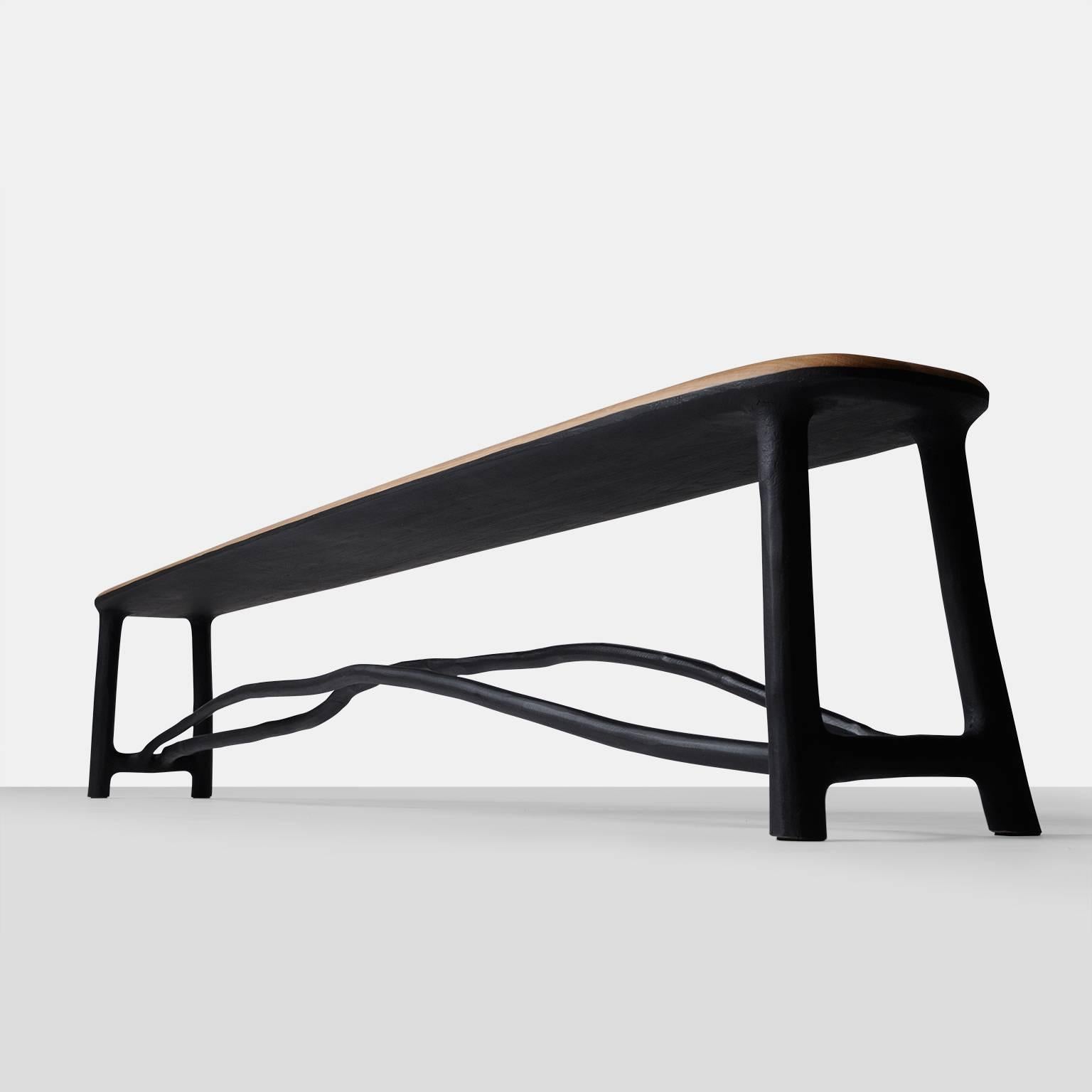 A very long and elegantly proportioned bench with a frame of naturally shaped hazel branches in a blackened finish while the seat is in oak. Each piece is completely handmade by Valentin Loellmann and all are signed and numbered.  With all custom