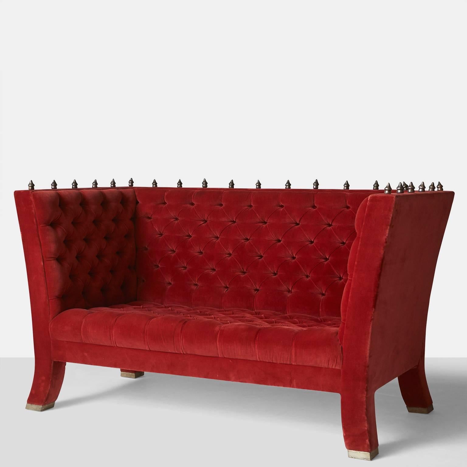 A pair of tufted sofas in red velvet with bronze Baroque finials lining the top edge and legs terminating with silver plated caps. A similar model is in the Pompidou Center in Paris. Manufactured by BGH Editions, Paris, circa 1989.

Literature:
