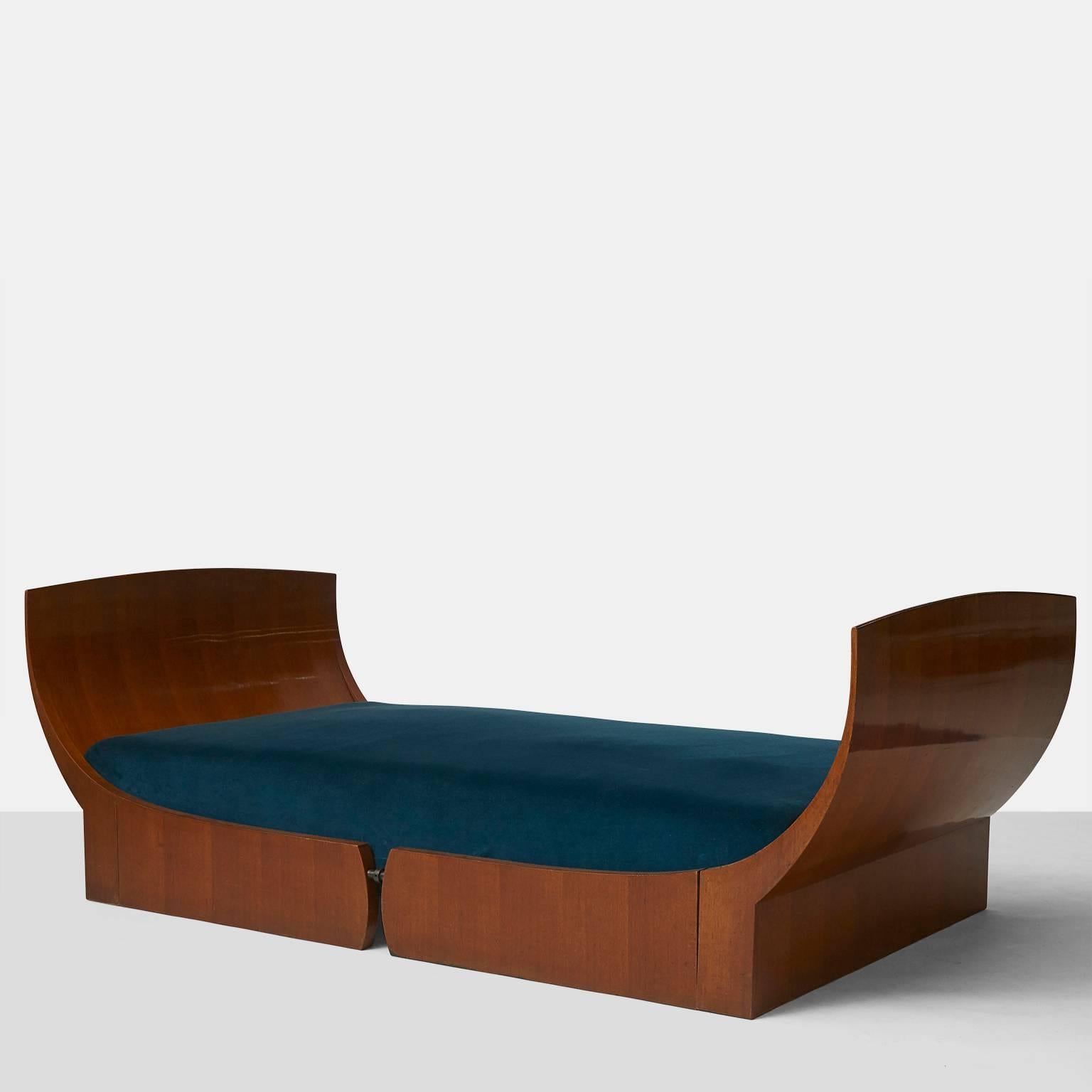 A classic and elegantly shaped walnut daybed by Luigi Caccia Dominioni and one of four only known examples. The bed is upholstered in a deep teal velvet and the graceful flared walnut panels on each end are attached at the base of the frame with an