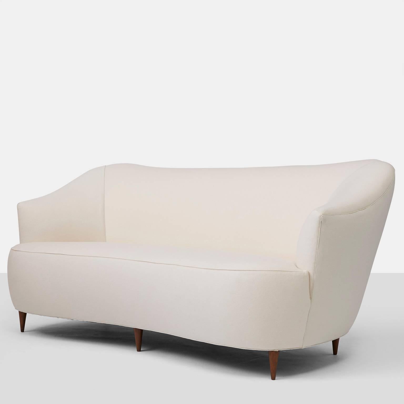 A rare sofa designed by Gio Ponti for Casa e Giardino, circa 1950. The elegant sofa has a curved front, out flared arms and curved back. Completely restored in a luxuriously soft wool fabric from Holland & Sherry fabrics with a contrast cord trim.