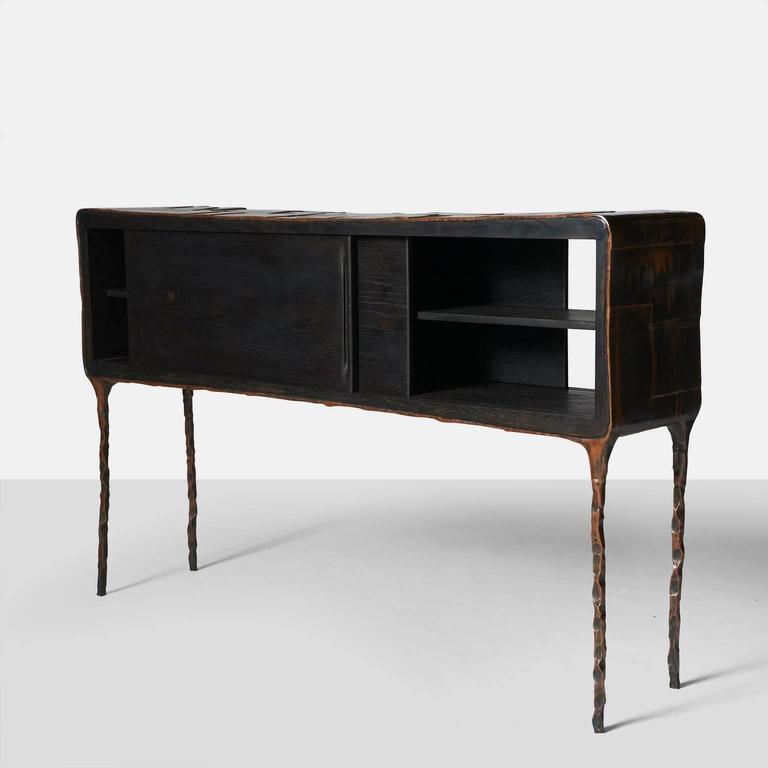 A console or credenza with two sliding doors and access from each side. The frame is hand worked and assembled copper with blackened oak doors and interior. 
Each piece is completely handmade by Valentin Loellmann and all are signed and numbered. 