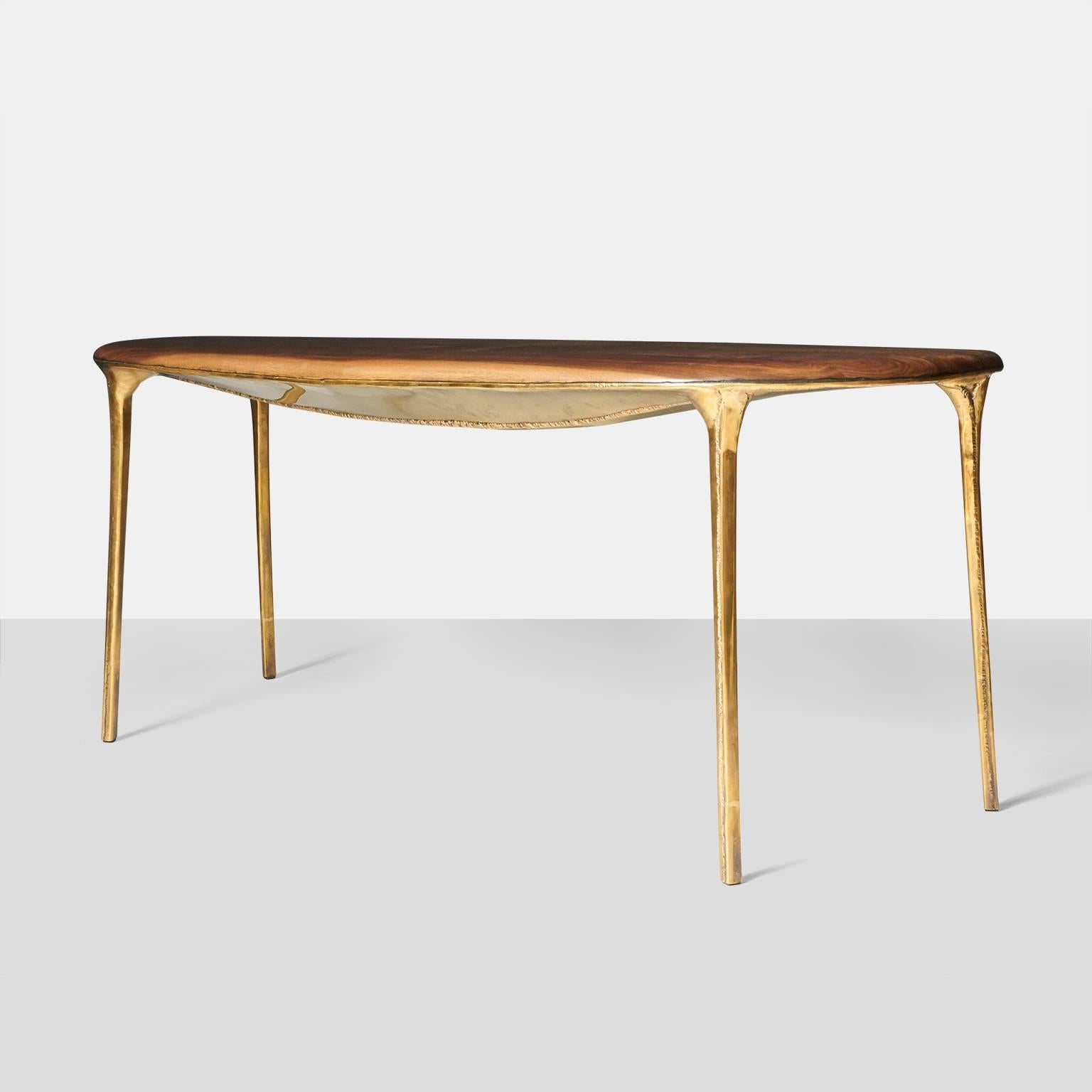 A dining table or desk by Valentin Loellmann in hand worked brass with a walnut top. The shape is an organic oval and the underside has a unique detail.
Each piece is completely handmade by Valentin Loellmann and all are signed and numbered. Almond