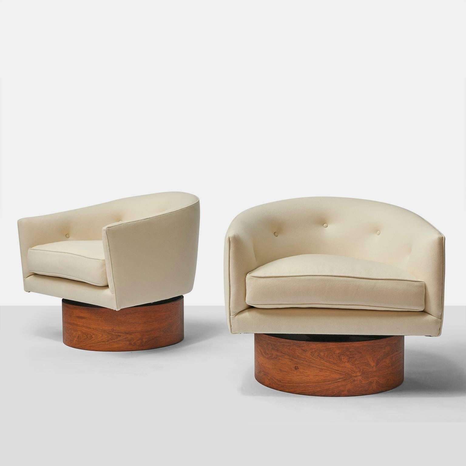 A pair of barrel shaped swivel club chairs by Milo Baughman for
Thayer Coggin. Features a walnut base and completely restored in a soft wool fabric from Holland & Sherry with down cushion fill, USA, circa 1960s.