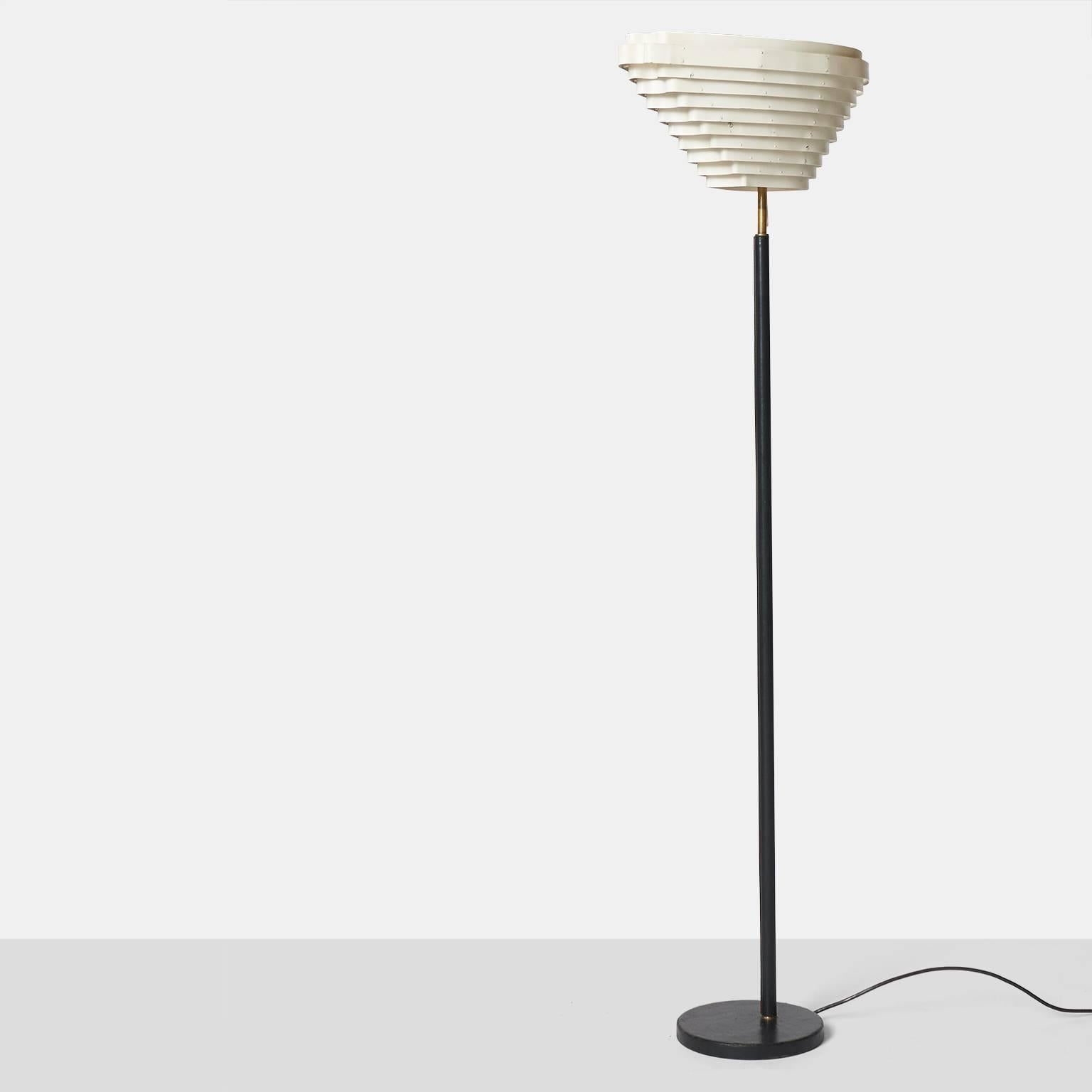 A floor lamp model #A805 by Alvar Aalto for Valaisinpaia. The base and stem have been wrapped in hand-sewn black leather with a white enameled metal shade. Nick named the Angel lamp for the asymmetrical shape of the shade.

  