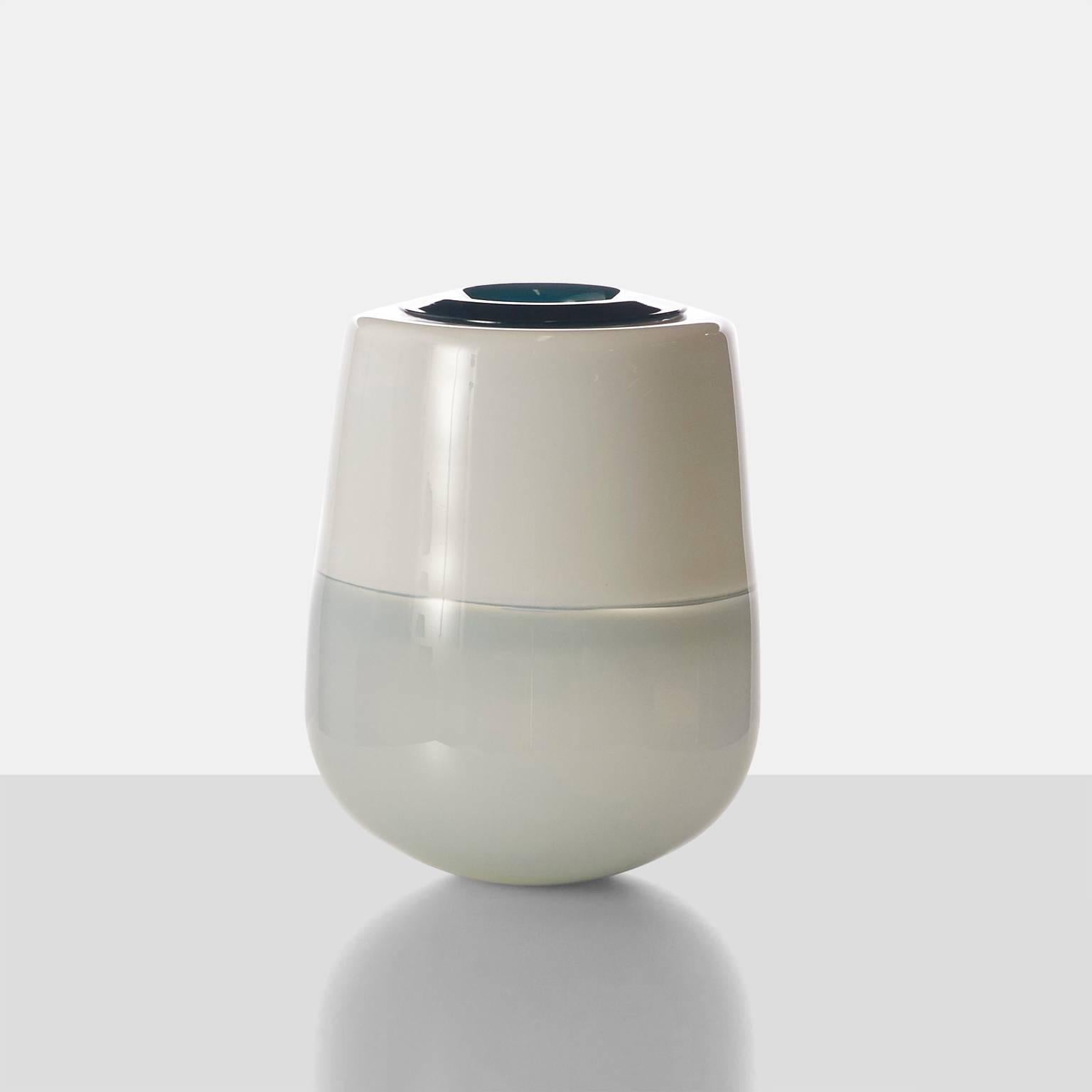 A free handblown vase with an insert for water. The glass has been blown in shades of ivory, grey and a teal color insert.