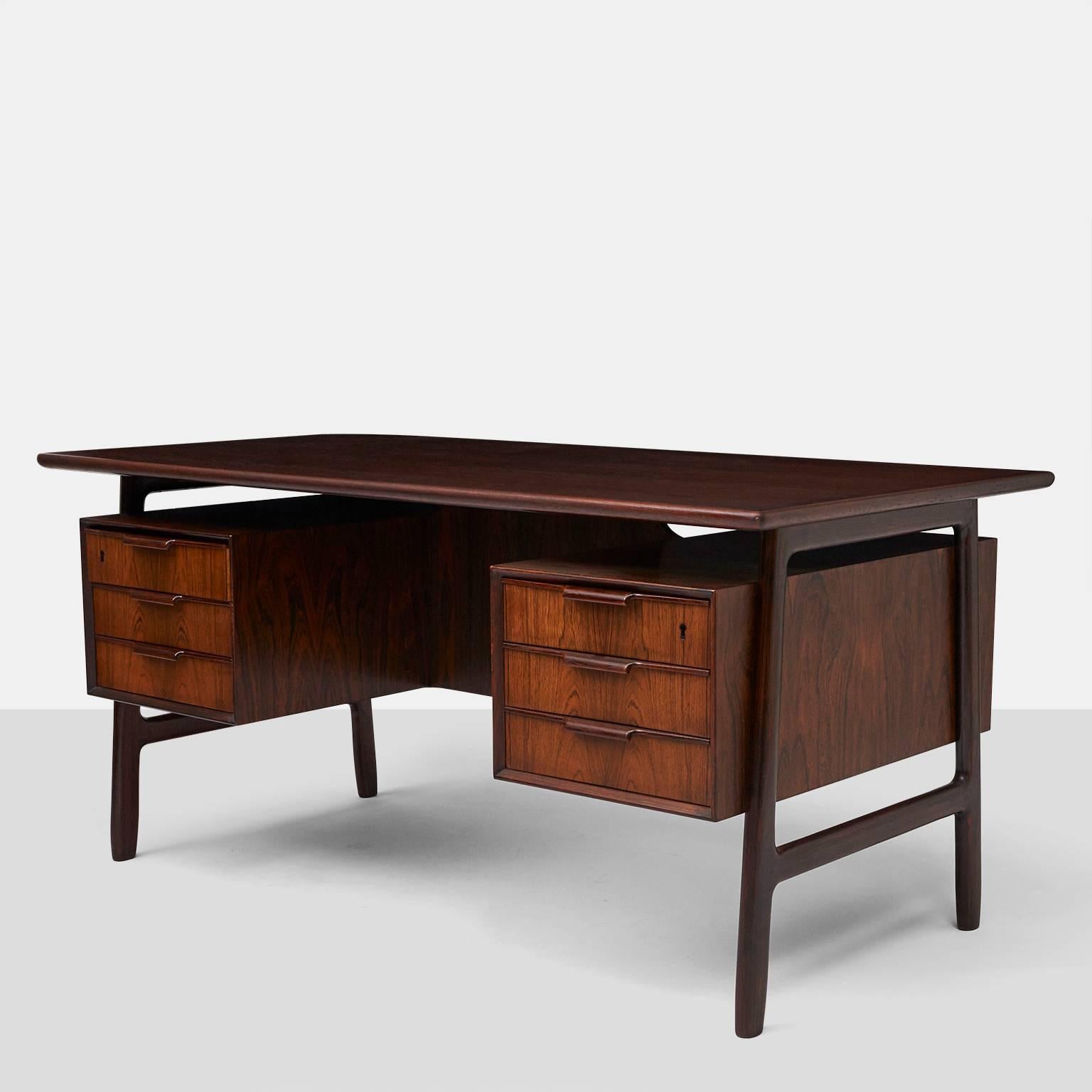 An Omann Jun rosewood Executive desk model #75. The front side has two pedestals with three drawers in each. The backside with two shelves, a storage compartment with drop down door and one privacy flap,
Denmark, circa 1950s.
  