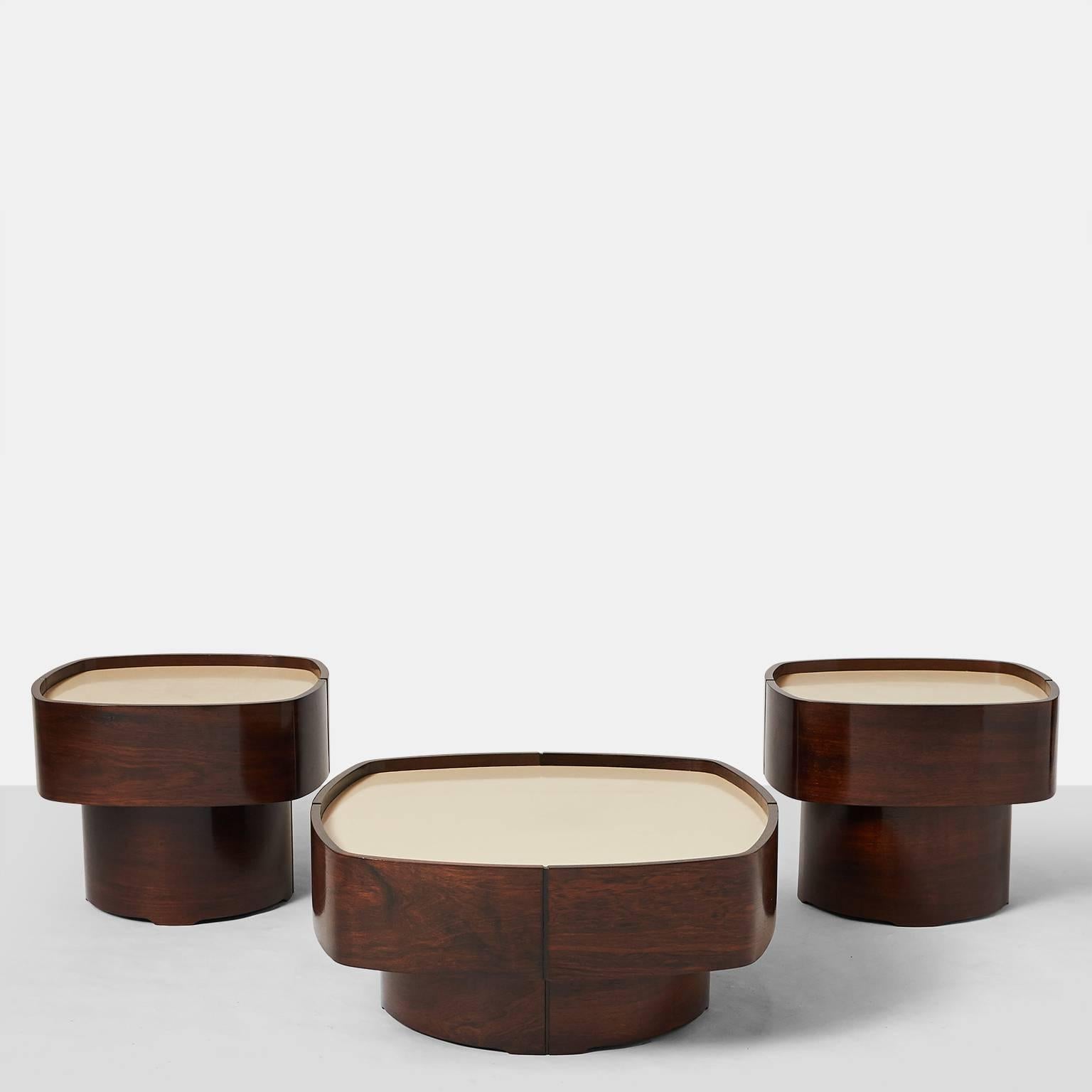 A suite of two side tables and one coffee table by Jorge Zalszupin for L' Atelier. The soft sideed tables are in a hardwood with almond color laminate top.
The side tables measure 20 x 17.5 x 17.5