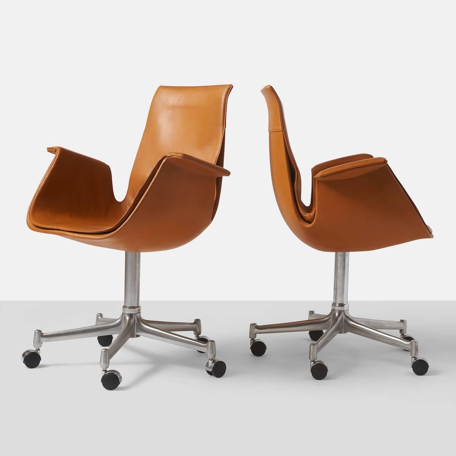 A pair of swivel base Bird chairs in cognac leather on chrome-plated steel frames. A total of two are available. Manufactured by Alfred Kill International.