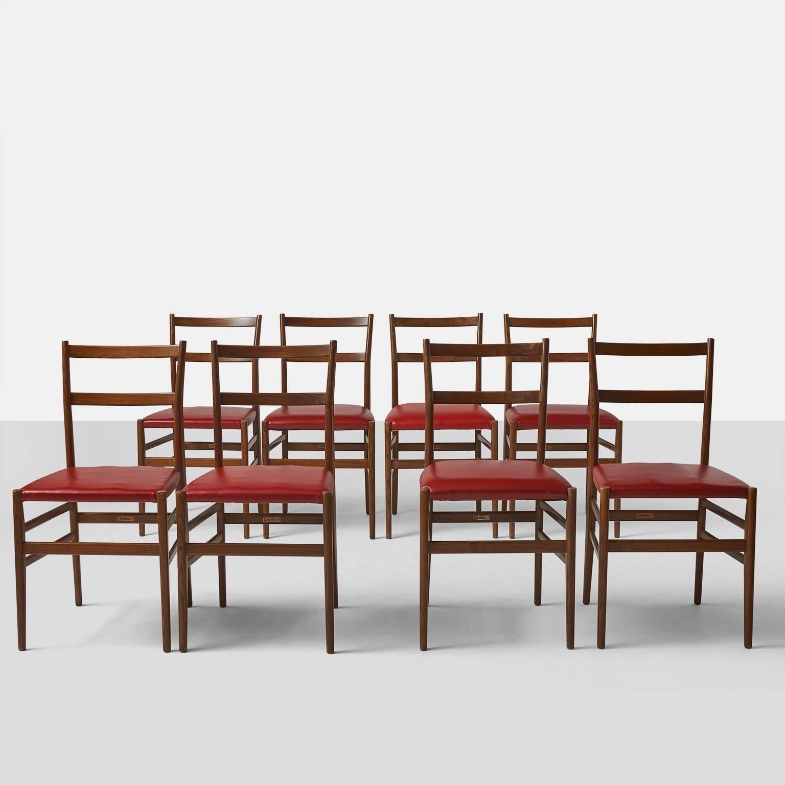 A set of two Leggera chairs by Gio Ponti for Cassina retaining the original labels. The seats have been upholstered in a deep red faux leather and a dark ash frame.