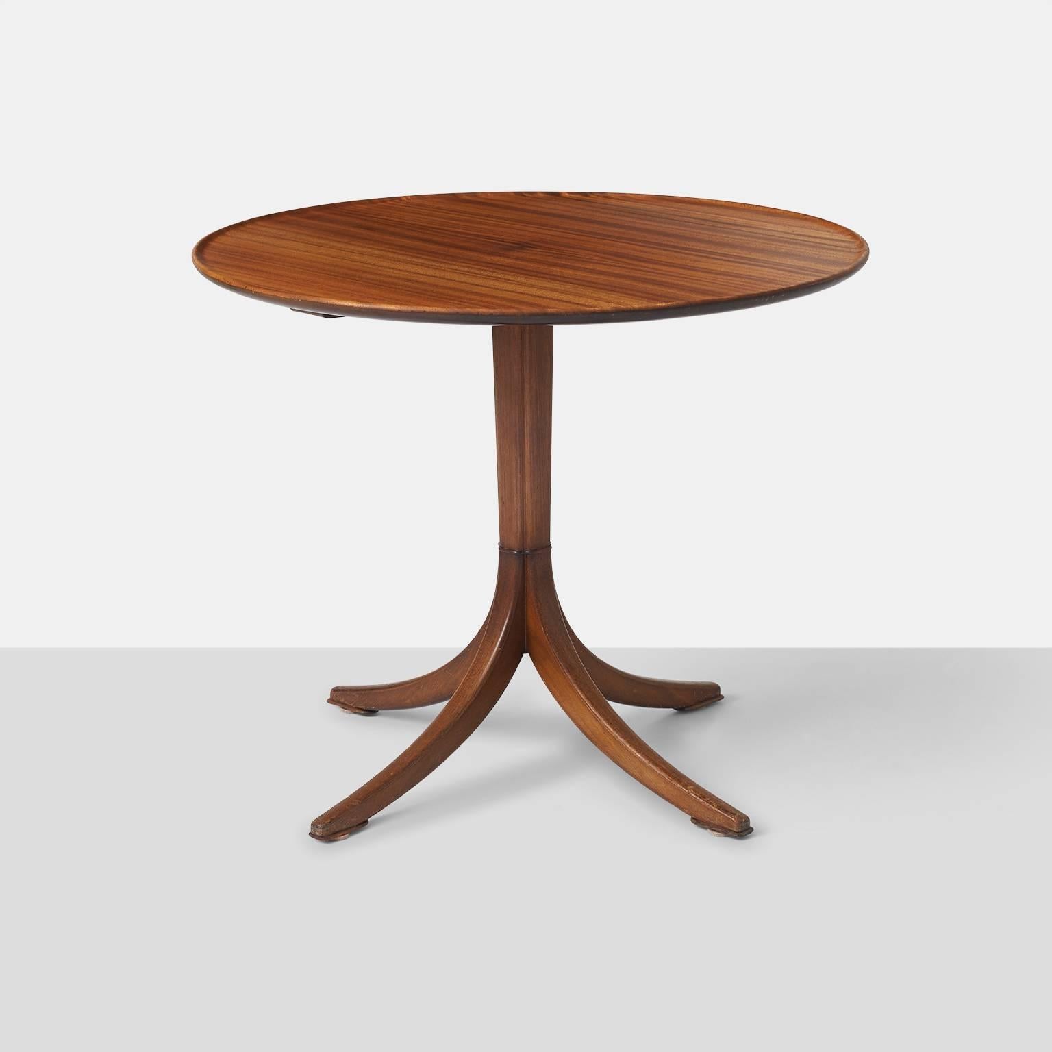 A circular side table in mahogany with a column stem and four star base. There is a matching table available that is slightly shorter and measures 22.5