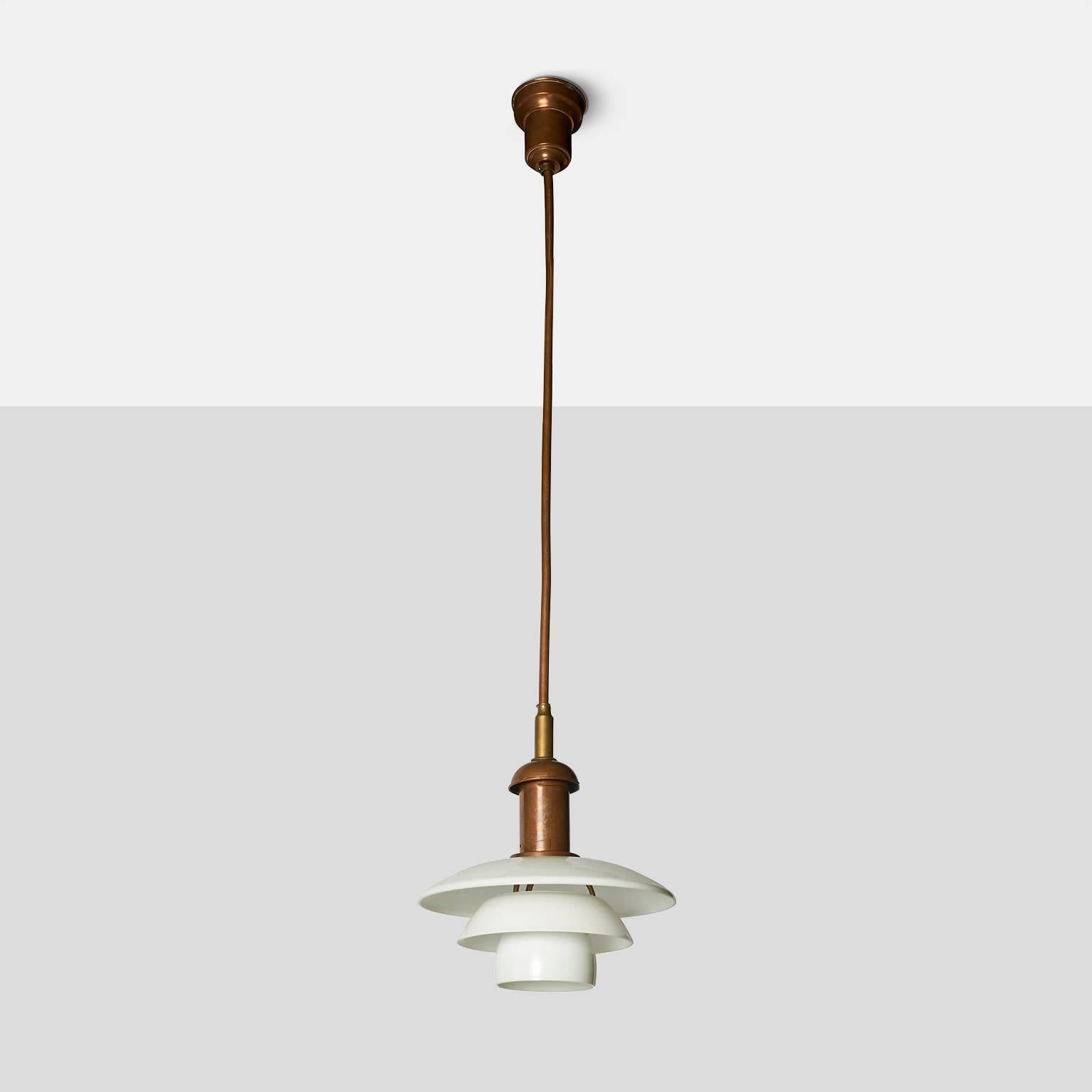 A very rare copper hanging lamp with fixed ceiling rod by Poul Henningsen for Louis Poulsen in 1926.
The pendant has a copper socket cover, stem and canopy and is fitted with opal glass, 3/3 shade set.
Denmark, circa 1926.