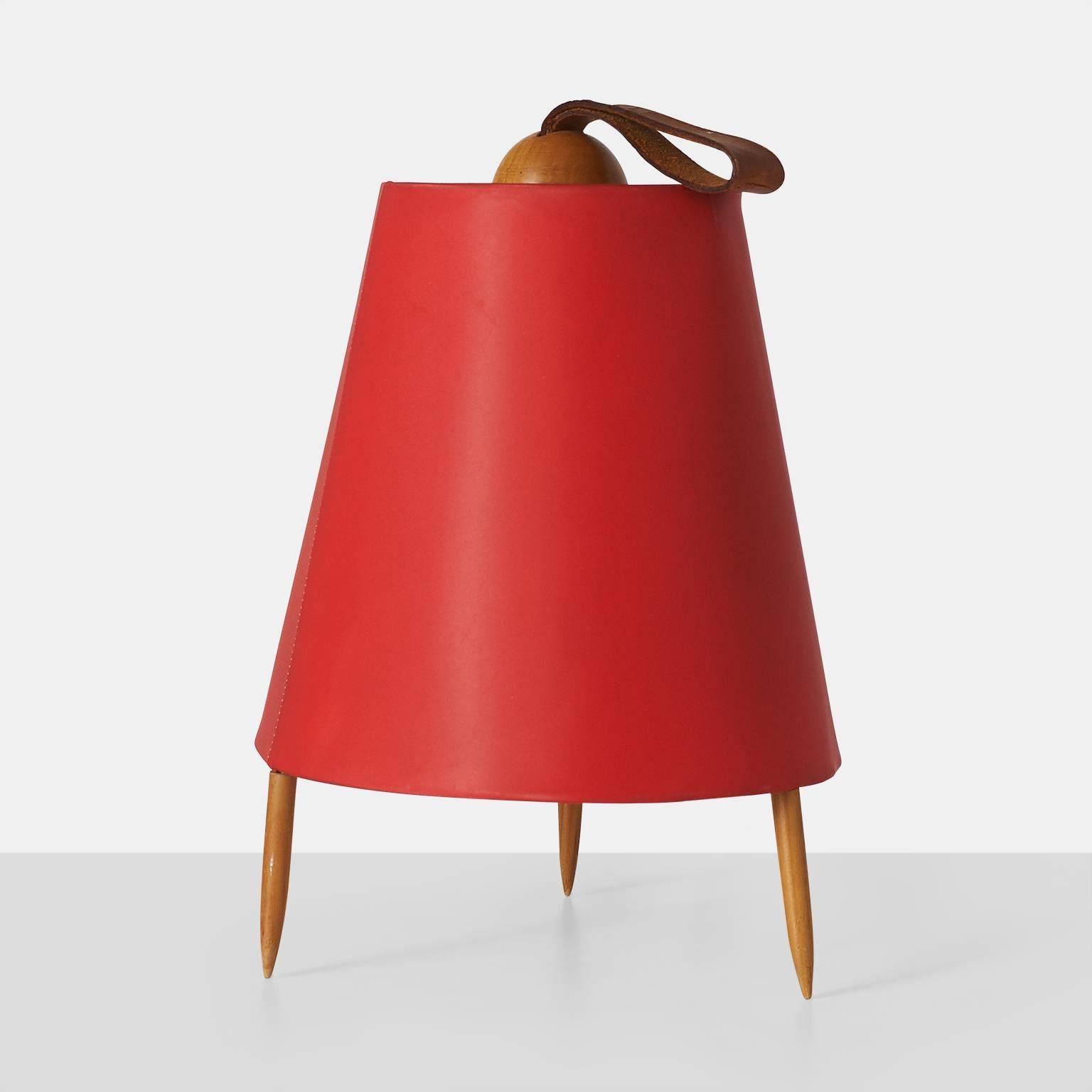 A desk or table lamp known as Eichhornchen or "squirrel" lamp in red lacquered linen with three teak legs and a leather loop at the top.
Made by J.T.Kalmar.
Austria, circa 1950s.

         