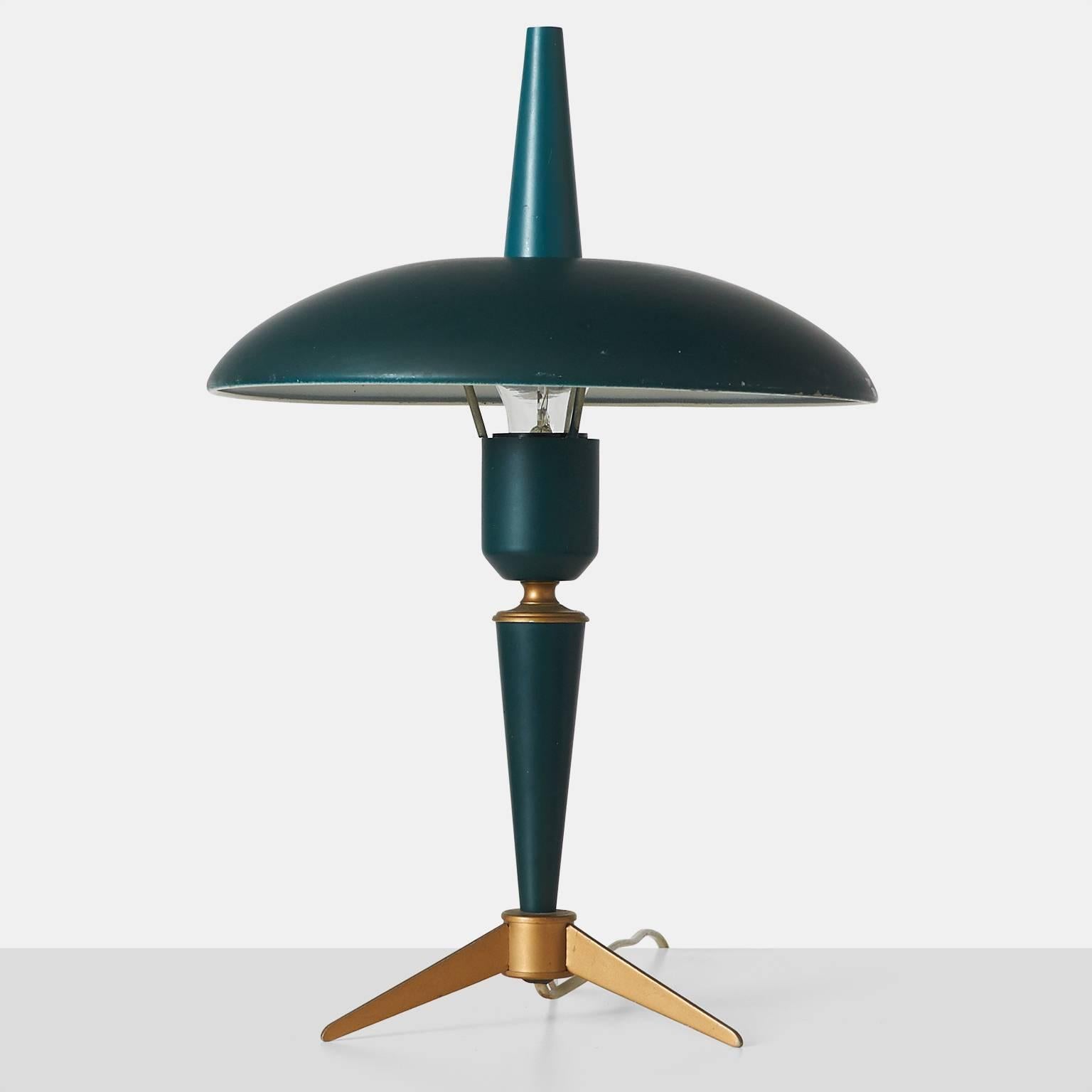 An elegant table lamp, designed by Louis Kalff for Philips, circa 1950s in the Netherlands. The lamp features a tripod brass base and lacquered deep blue/green and retains the original cone shaped finial missing from most other versions.
 