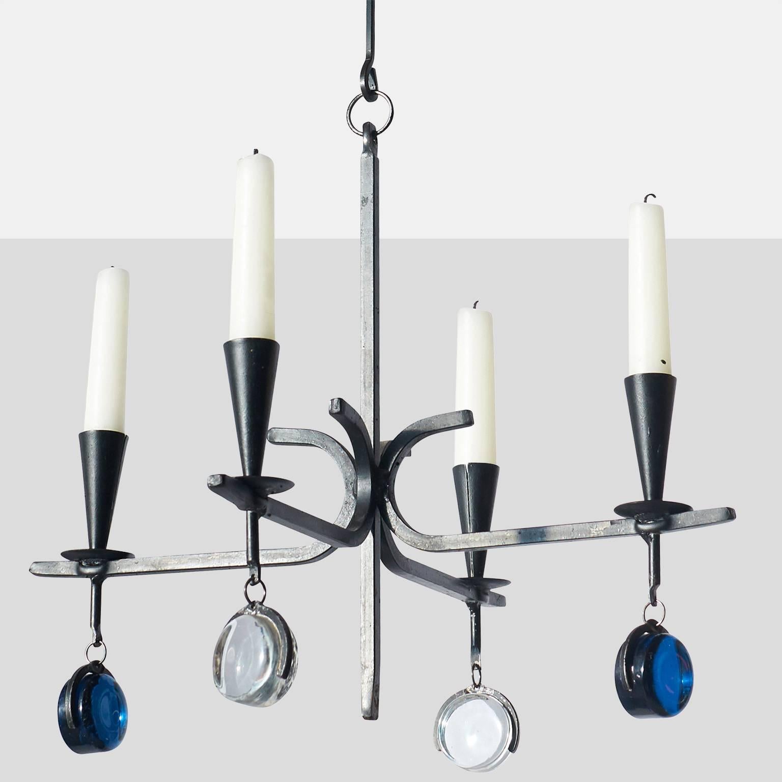 An iron candelabra with four arms for candles for Kosta Boda with blue and clear glass finials on each arm.  
Denmark, circa 1960s.
