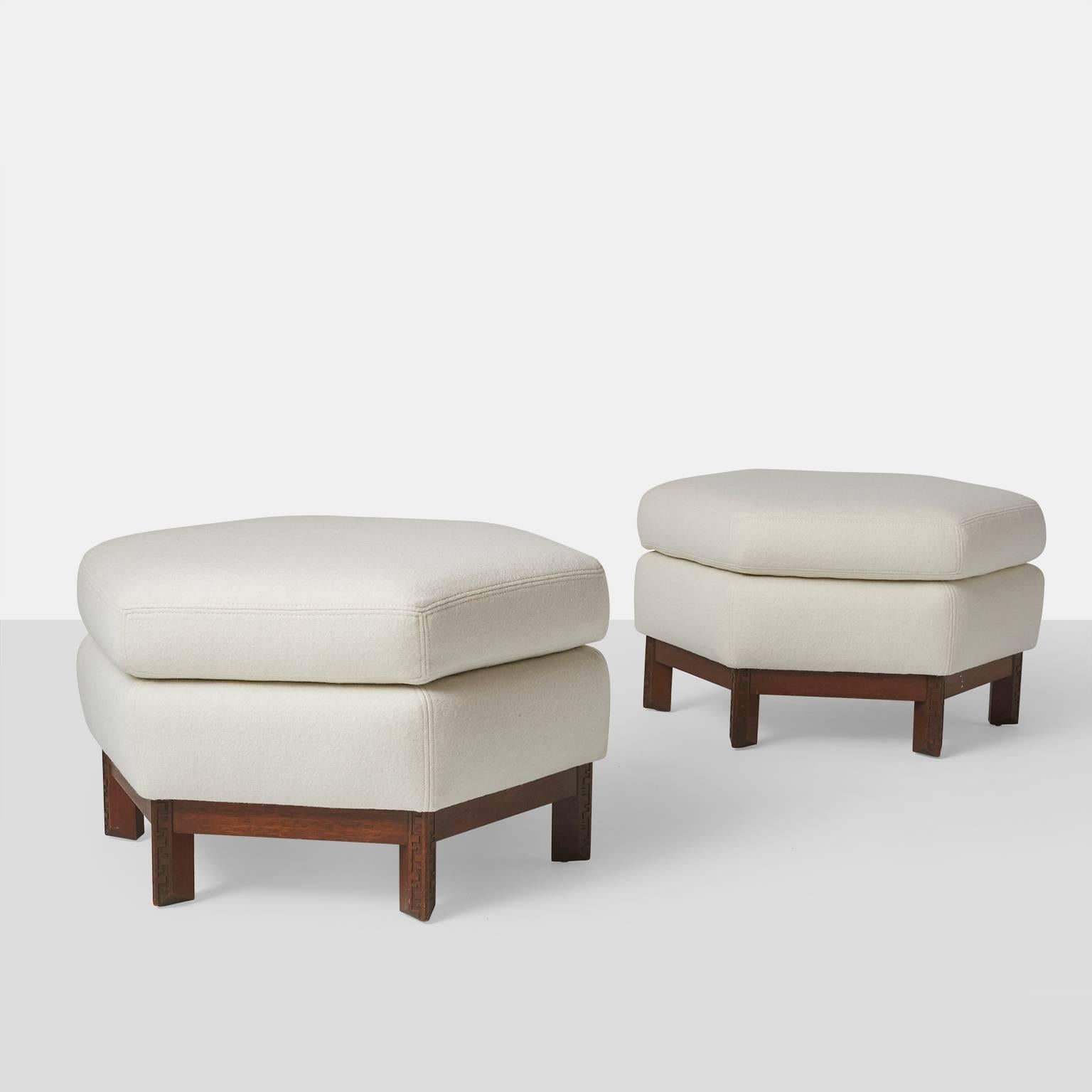 A pair of Frank Lloyd Wright hexagonal ottomans, each having a semi attached seat cushion, and rising on geometric Taliesin style mahogany legs. Restored in a luxurious boiled wool fabric from Holland & Sherry. Manufactured by Henredon.

Ottomans