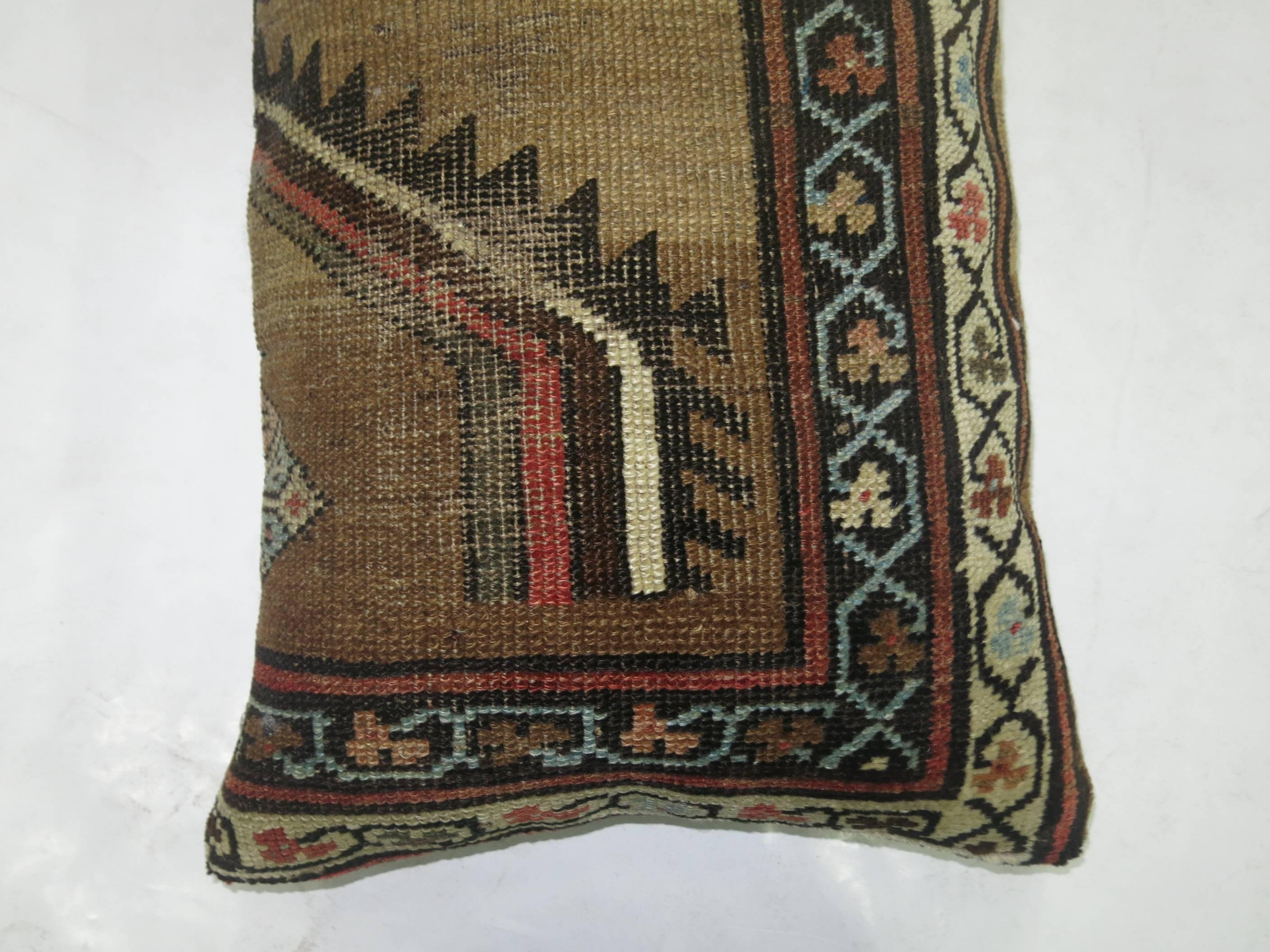 Pillow made from a 19th-century antique Persian serab rug backed in khaki cotton.