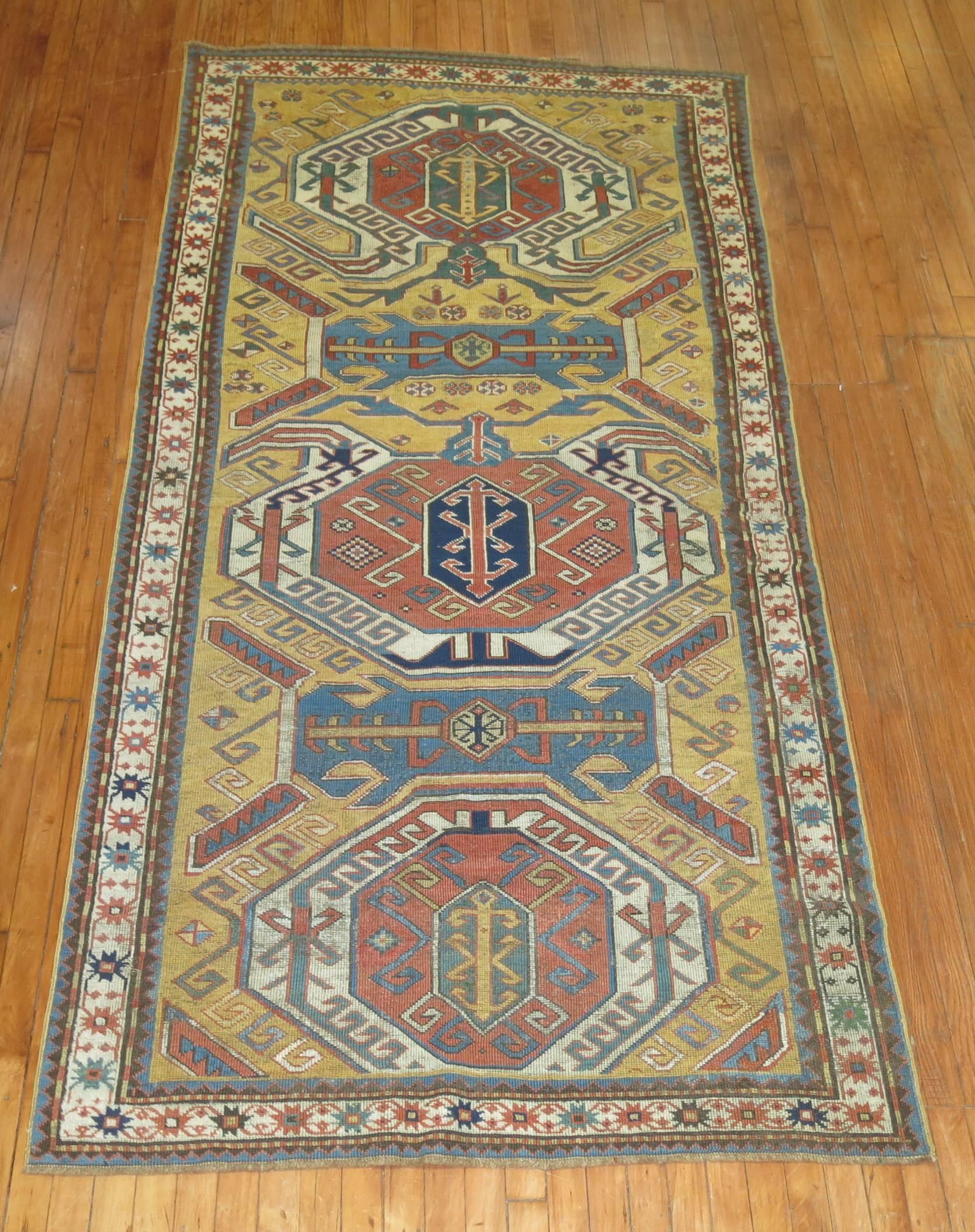 An antique Kazak rug with a mustard colored background. Measures: 4'3” x 9'2”

Kazak is in the Republic of Armenia, directly to the North West of Lake Sewan. In weaving terms, Kazak is probably the most famous area in the Caucasus, for the best of